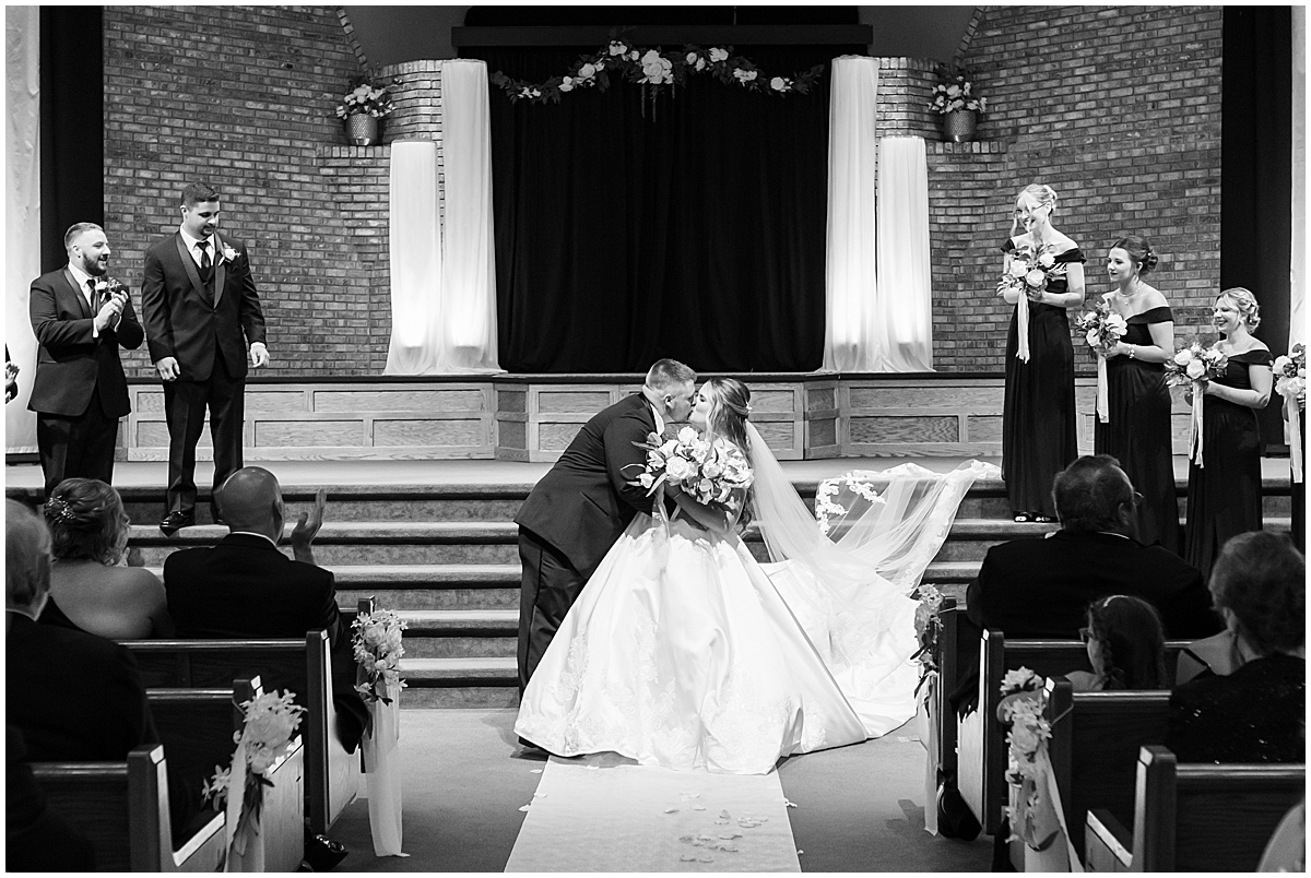 Bride and groom kiss at wedding in at Converse Church of Christ in Converse, Indiana