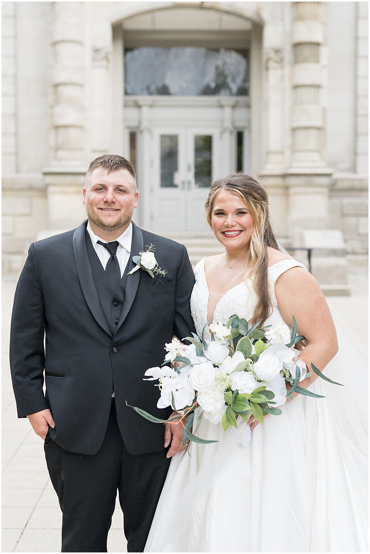 Bride and groom in front of doorway for wedding photos at Hamilton County Courthouse in downtown Noblesville, Indiana 