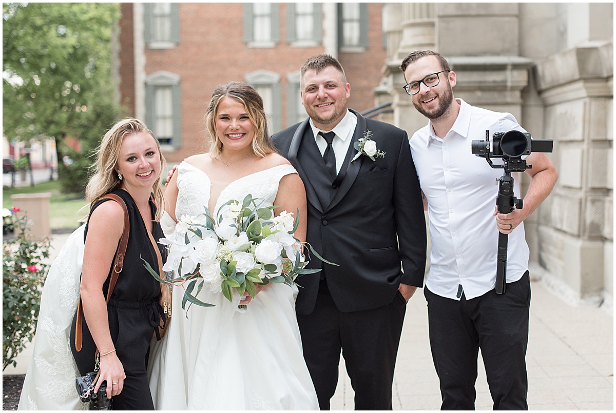 Bride and groom with photographer and videographer at wedding photos at Hamilton County Courthouse in downtown Noblesville, Indiana 