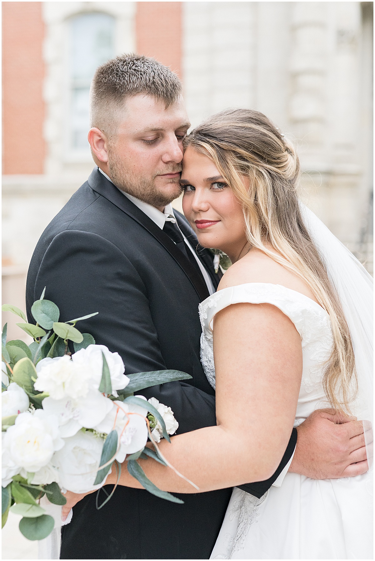 Newlyweds hug during wedding photos at Hamilton County Courthouse in downtown Noblesville, Indiana