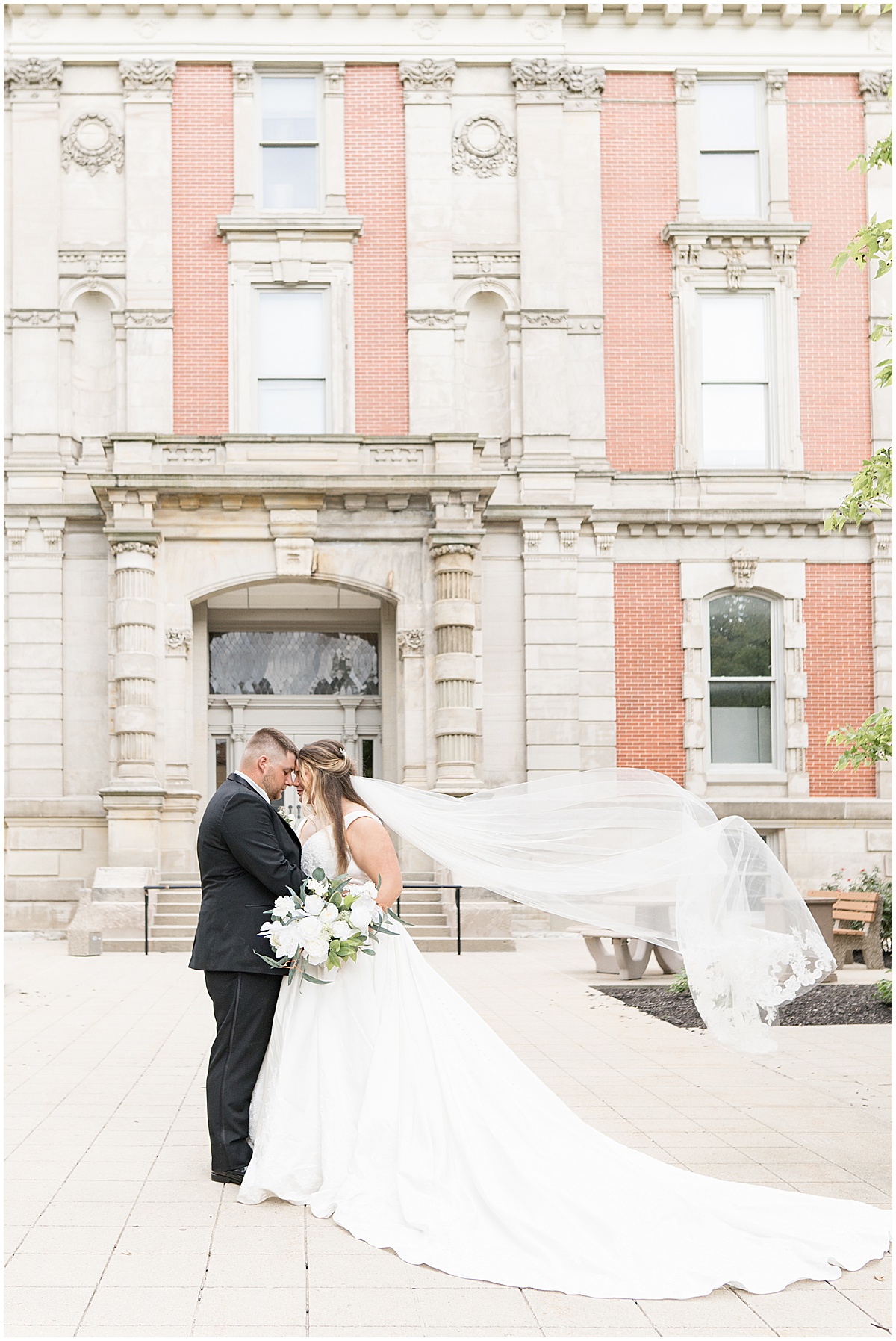 Bride and groom in front of doorway during wedding photos at Hamilton County Courthouse in downtown Noblesville, Indiana 