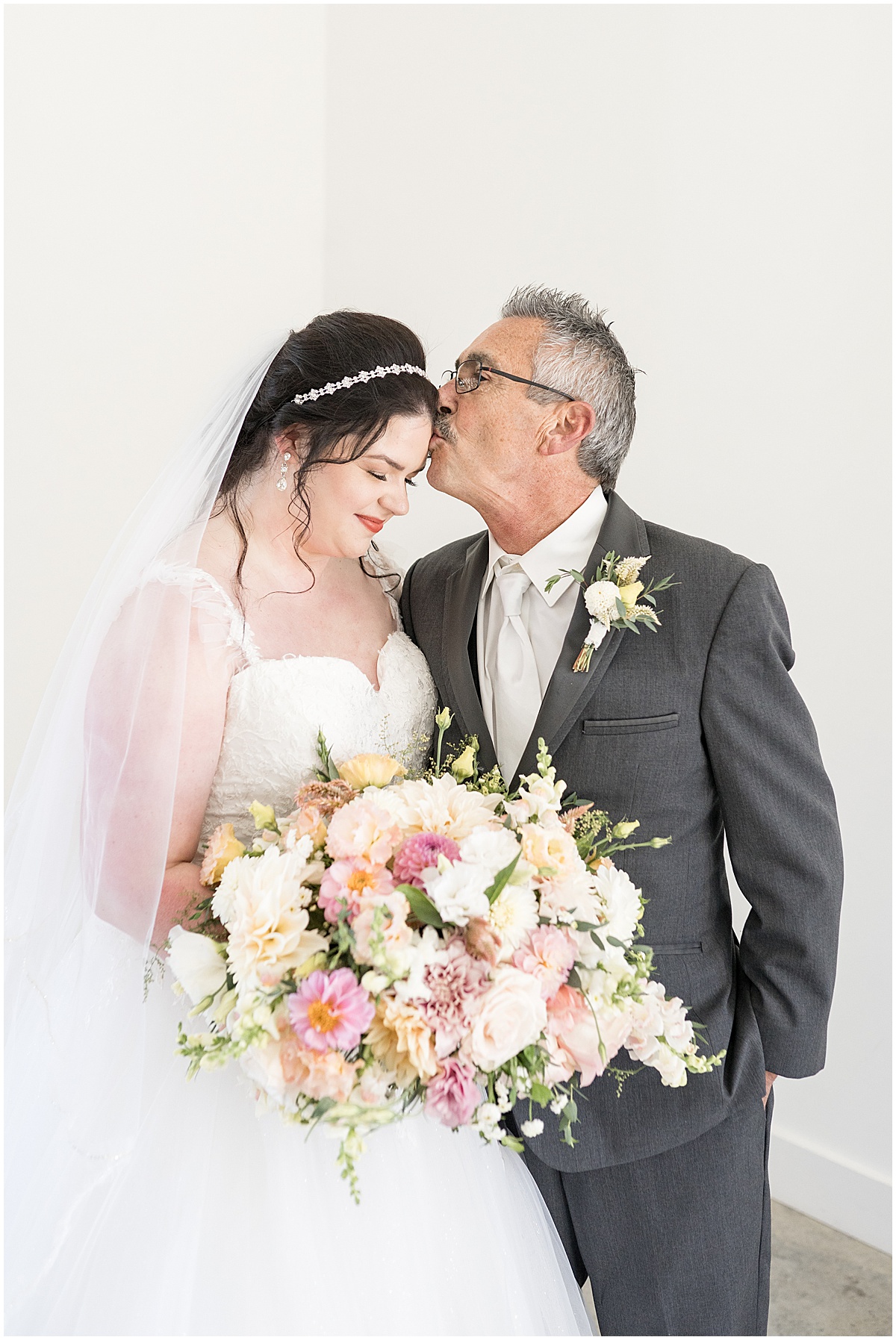 Father of groom kisses daughter before pastel wedding at New Journey Farms in Lafayette, Indiana