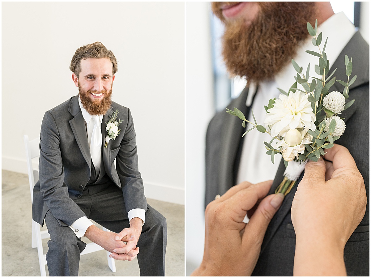 Groom getting on boutonnière before pastel wedding at New Journey Farms in Lafayette, Indiana