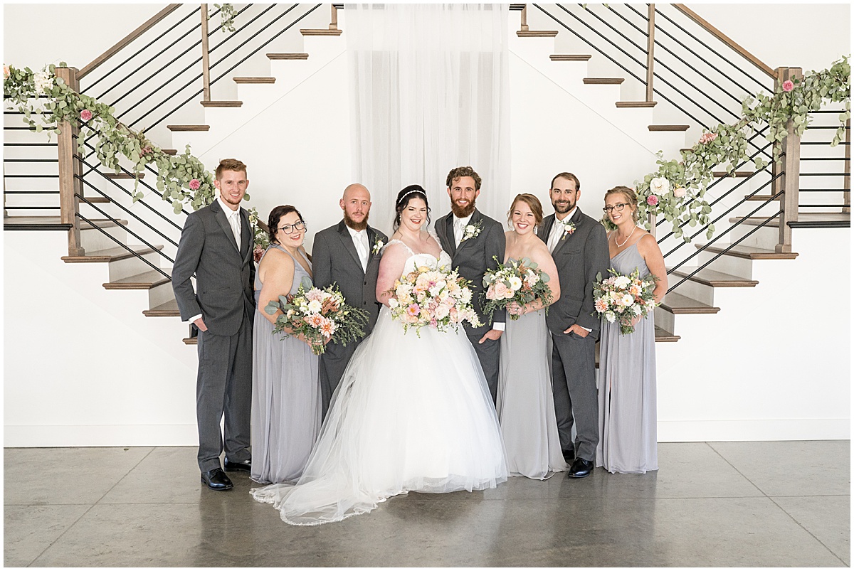 Bridal party photos in front of grand staircase for pastel wedding at New Journey Farms in Lafayette, Indiana