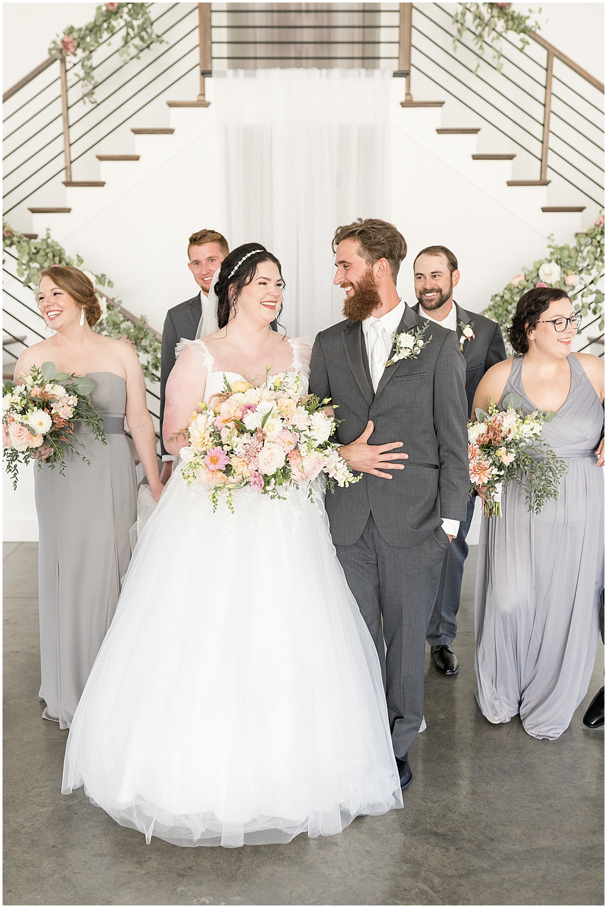 Bride and groom walk with bridal party before pastel wedding at New Journey Farms in Lafayette, Indiana