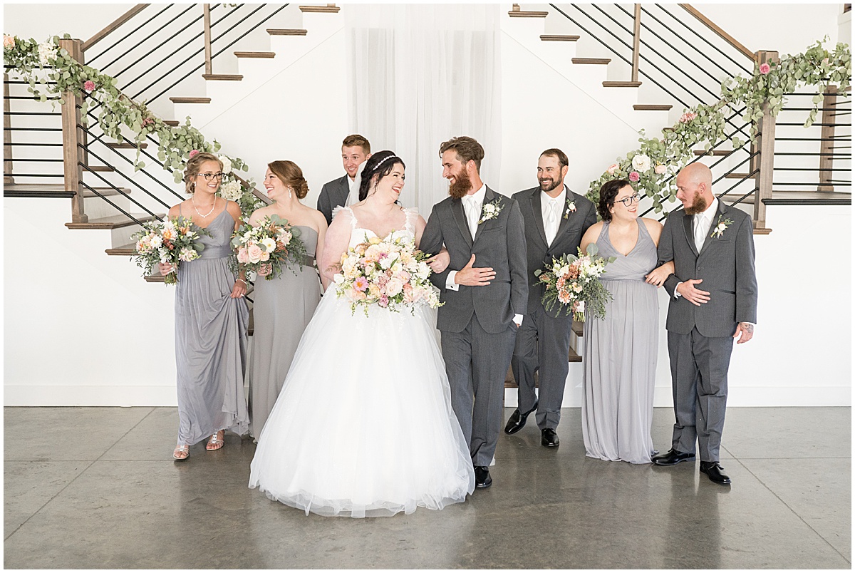 Couple walks with bridal party at pastel wedding at New Journey Farms in Lafayette, Indiana