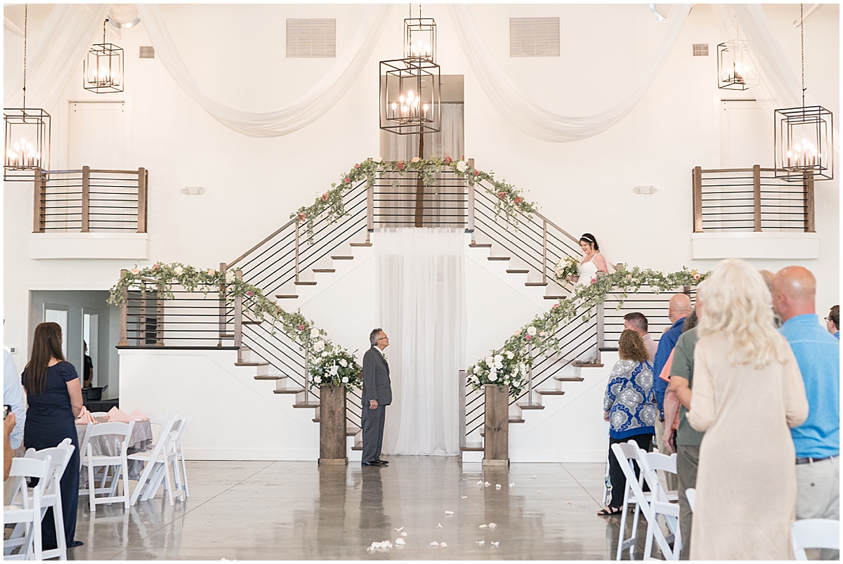 Bride walking down staircase to aisle for pastel wedding at New Journey Farms in Lafayette, Indiana