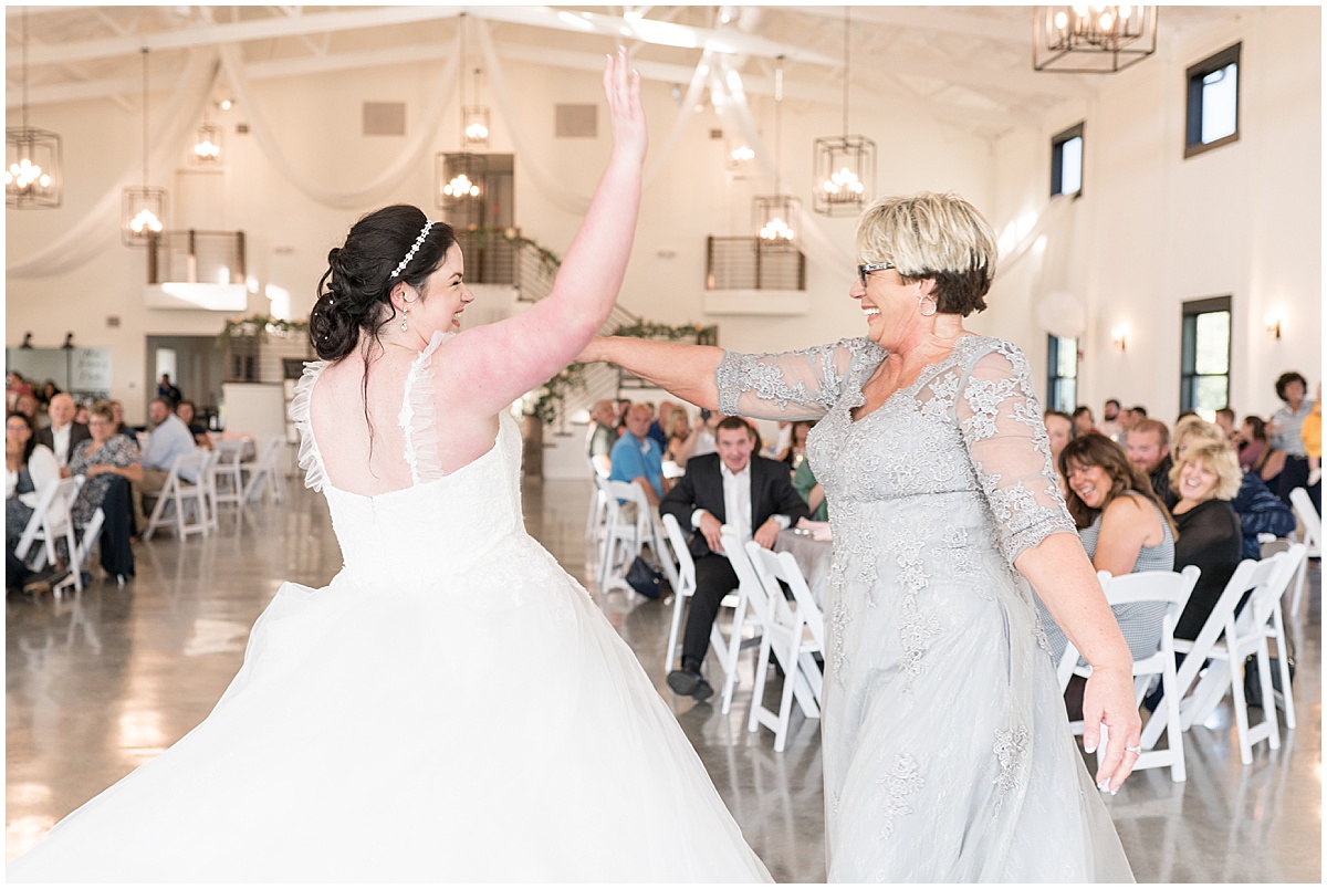 Couple dances with parents at pastel wedding at New Journey Farms in Lafayette, Indiana