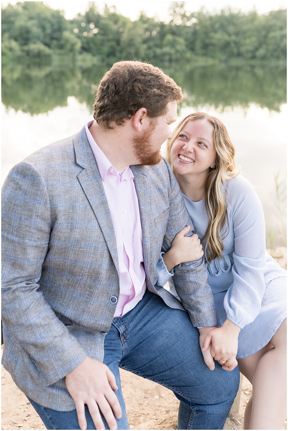 Couple look into each others eyes while sitting on bench during summer engagement photos at Fairfield Lakes Park
