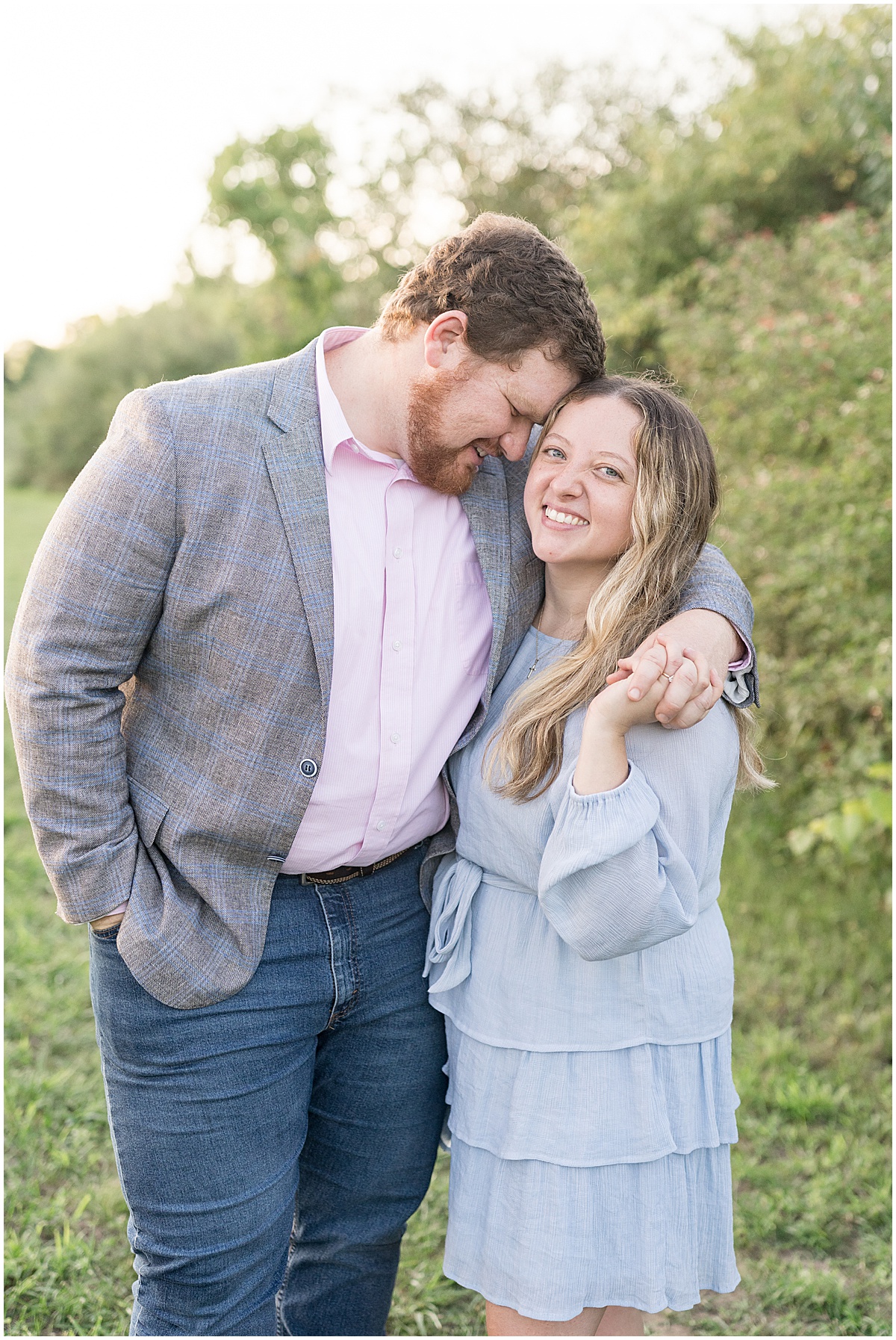 Couple hugging during summer engagement photos at Fairfield Lakes Park