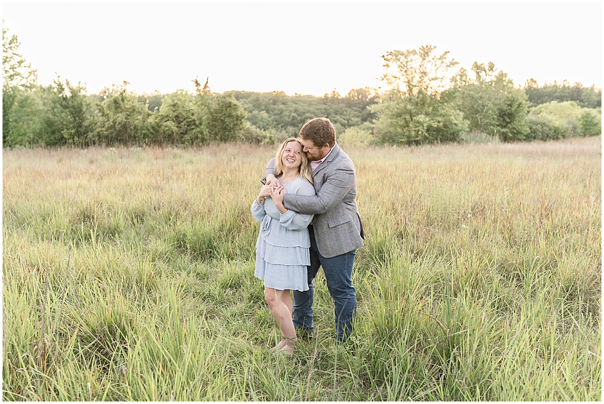 Couple in grassy field during summer engagement photos at Fairfield Lakes Park