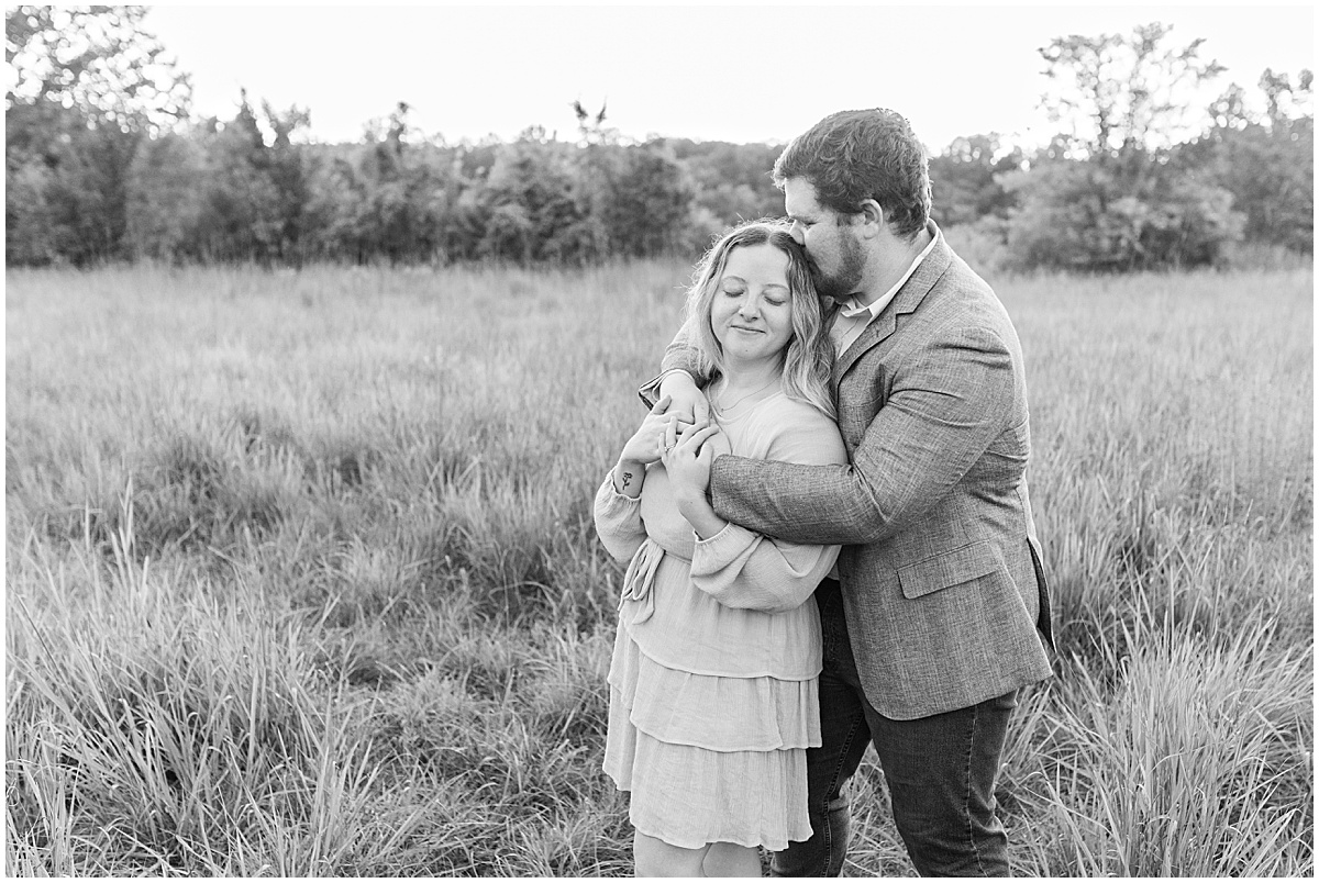 Man kisses fiancee's head during summer engagement photos at Fairfield Lakes Park
