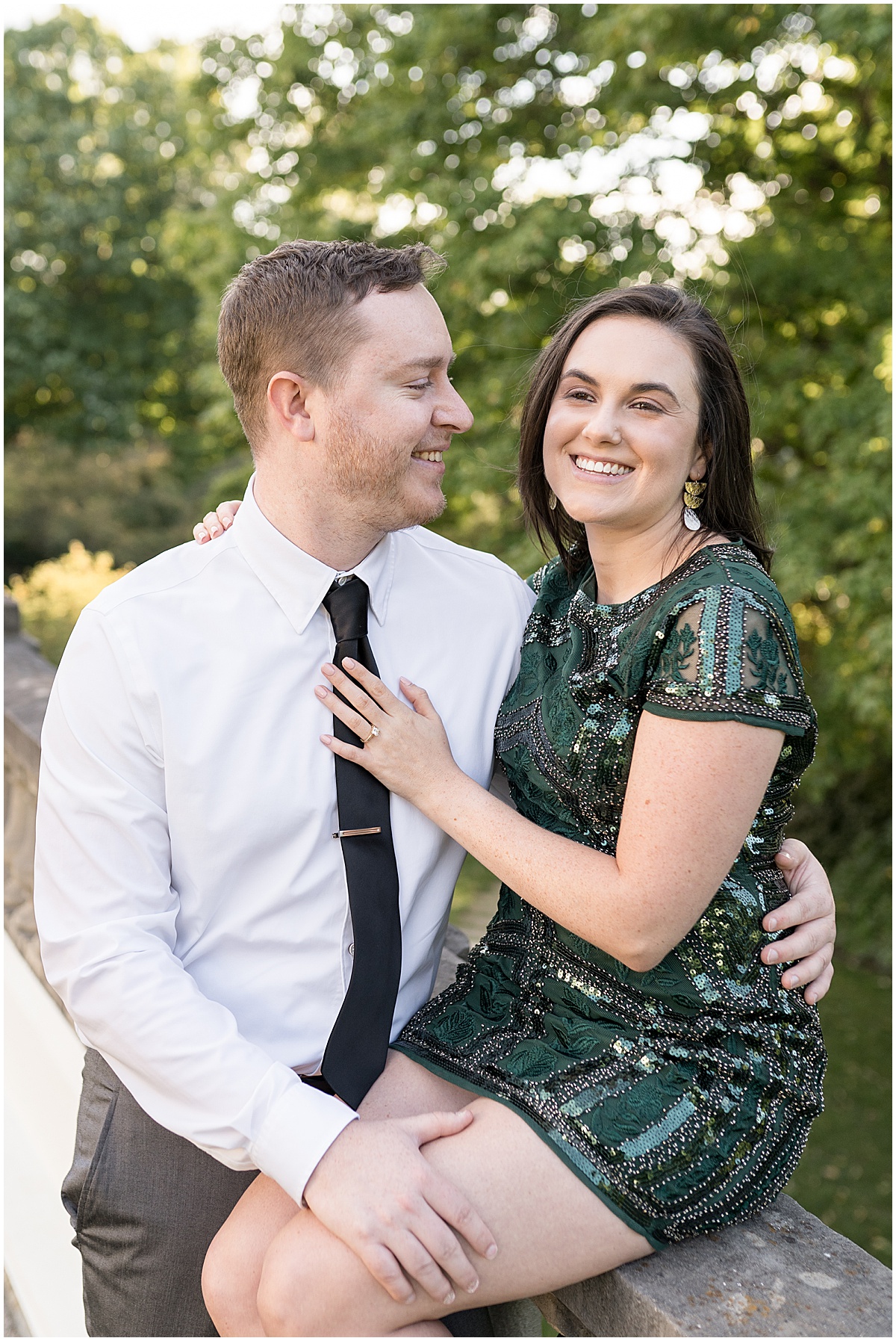 Couple laughing during jewel tone engagement photos at Newfields