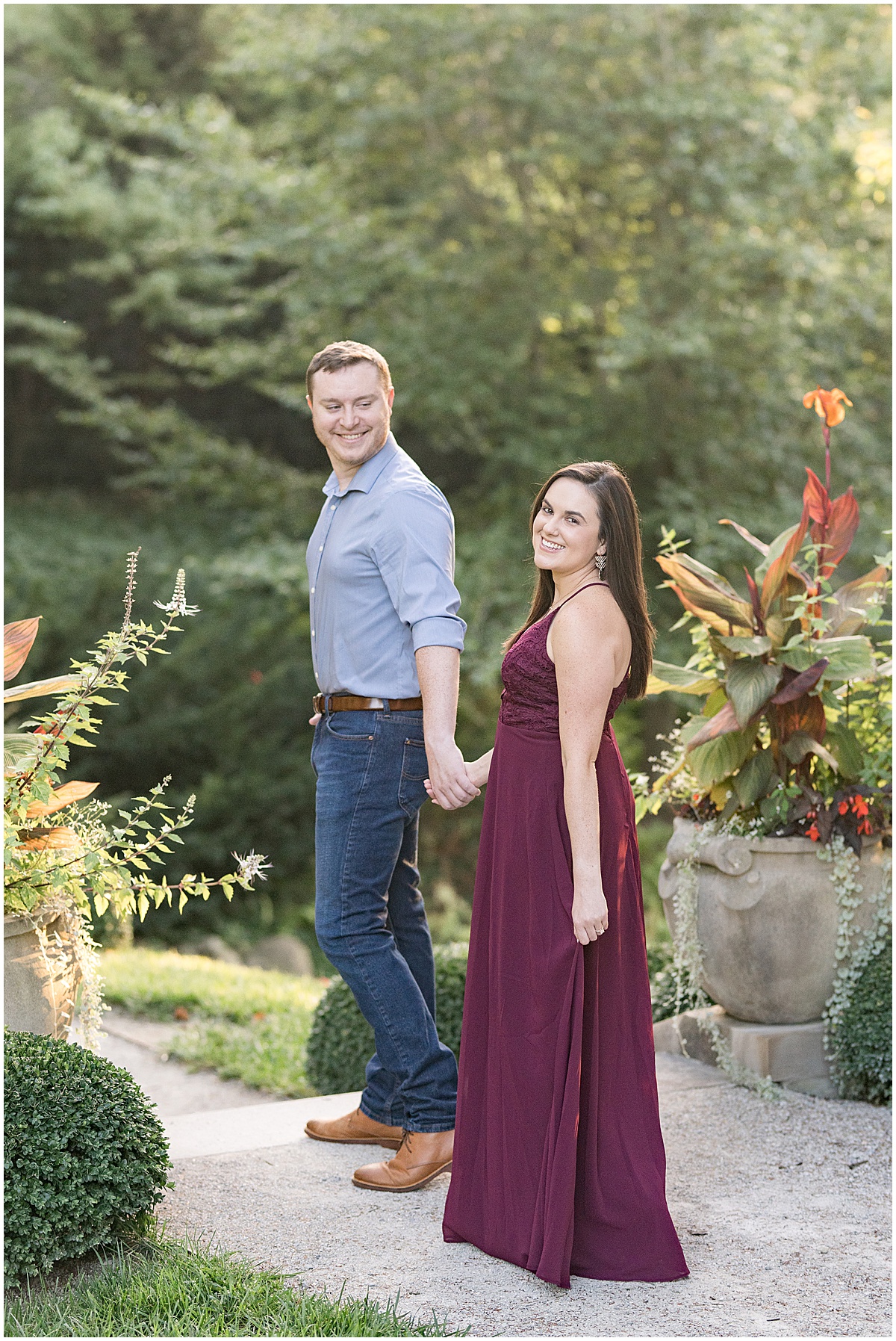 Couple walk on path during jewel tone engagement photos at Newfields