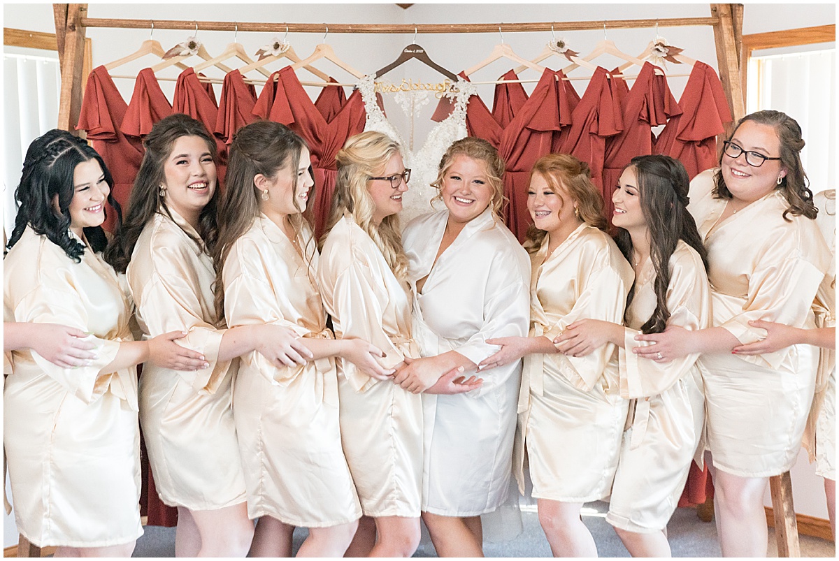 Bride with bridesmaids in matching robes before Miami County Fairgrounds wedding in Peru, Indiana