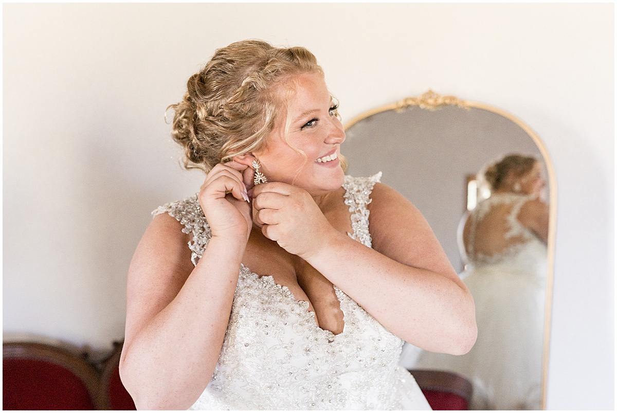Bride putting on earrings for Miami County Fairgrounds wedding in Peru, Indiana