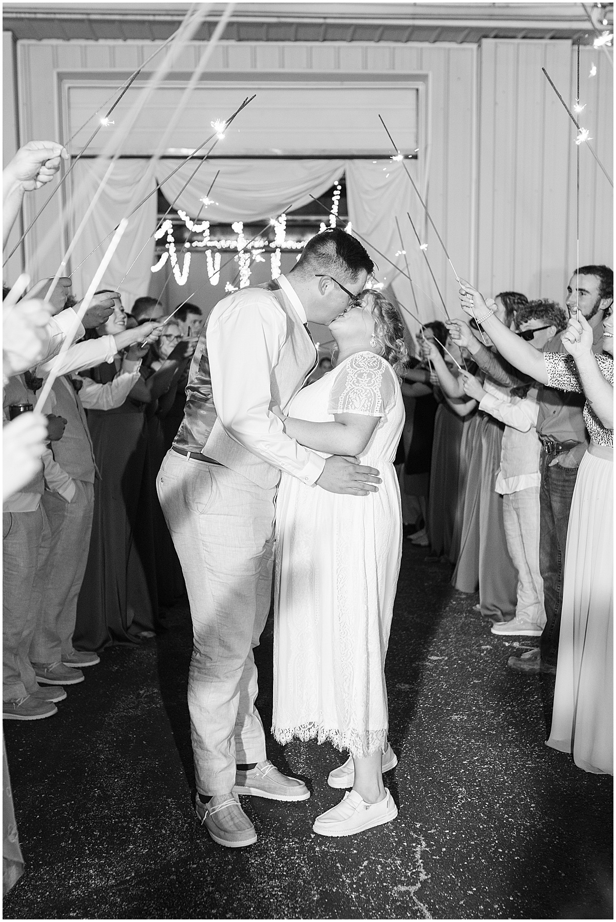 Bride and groom kiss during grand exit of Miami County Fairgrounds wedding in Peru, Indiana