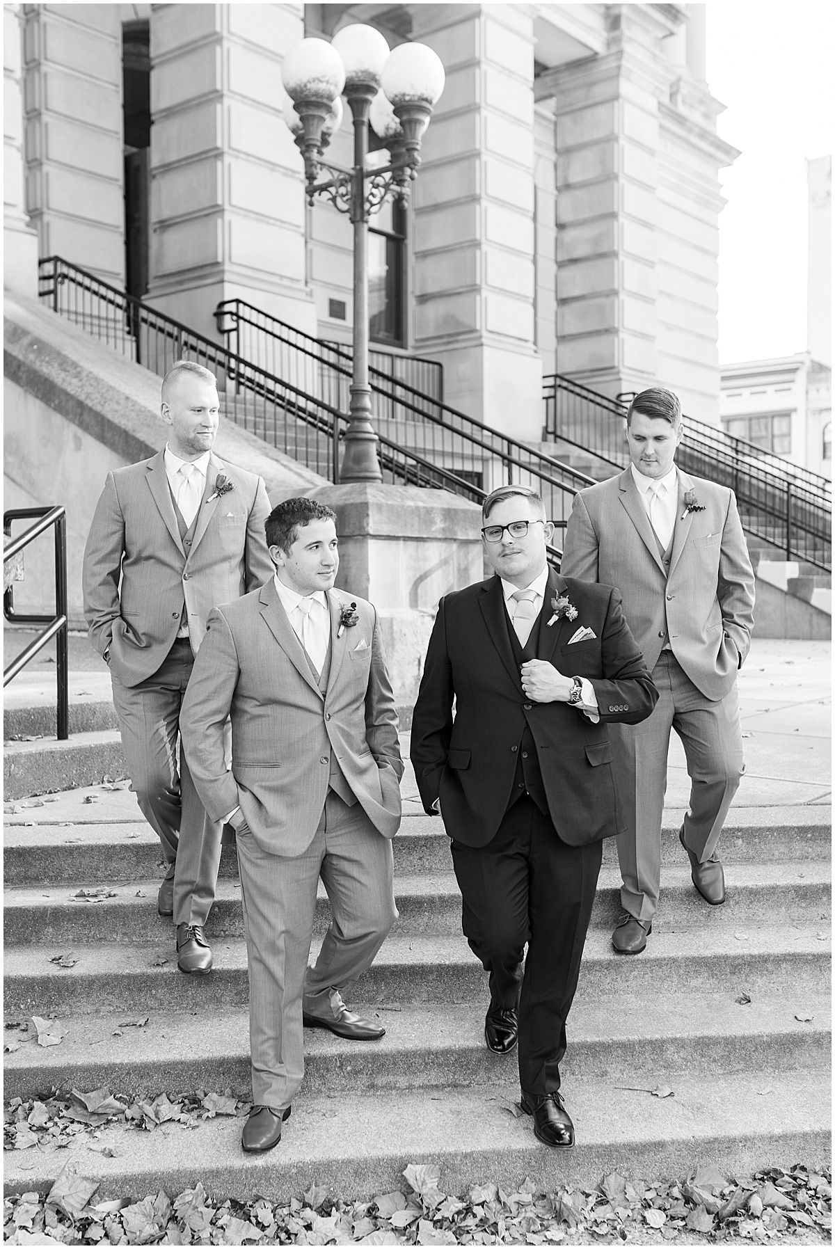 Groomsmen walking down steps during wedding photos in Downtown Lafayette, Indiana