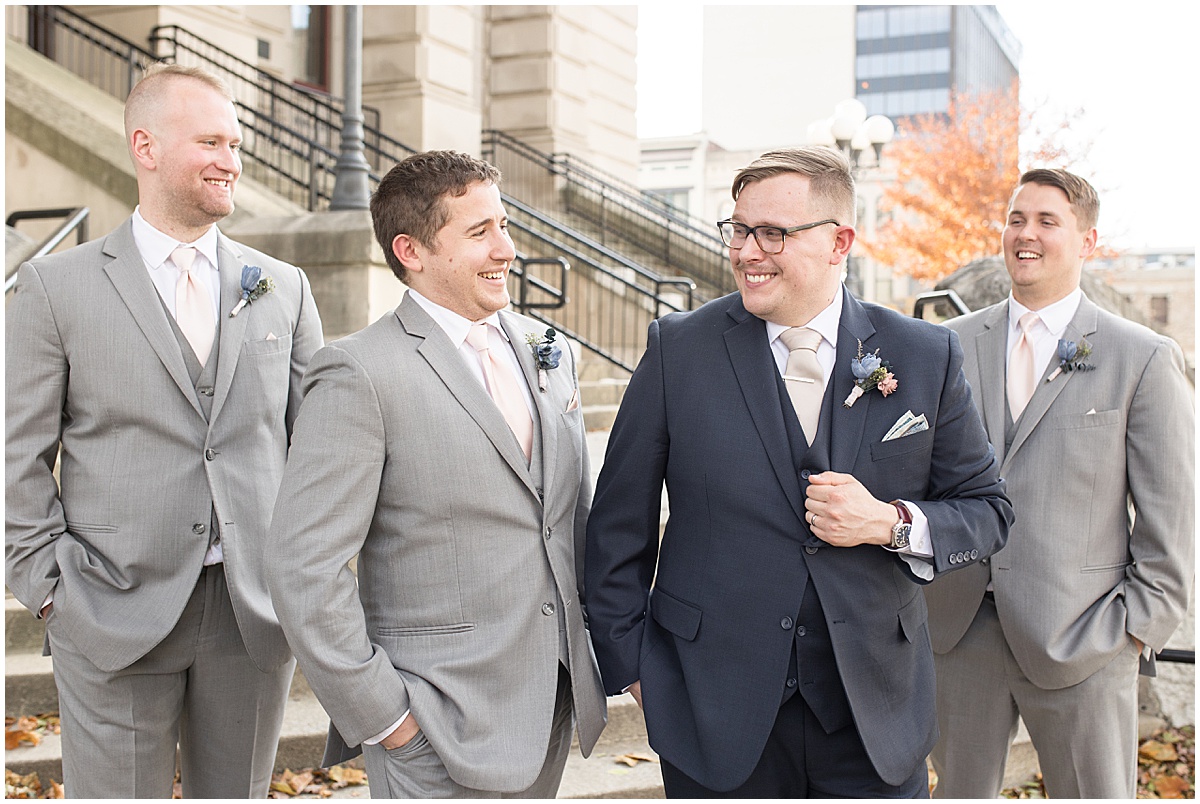 Groomsmen laughing during wedding photos in Downtown Lafayette, Indiana