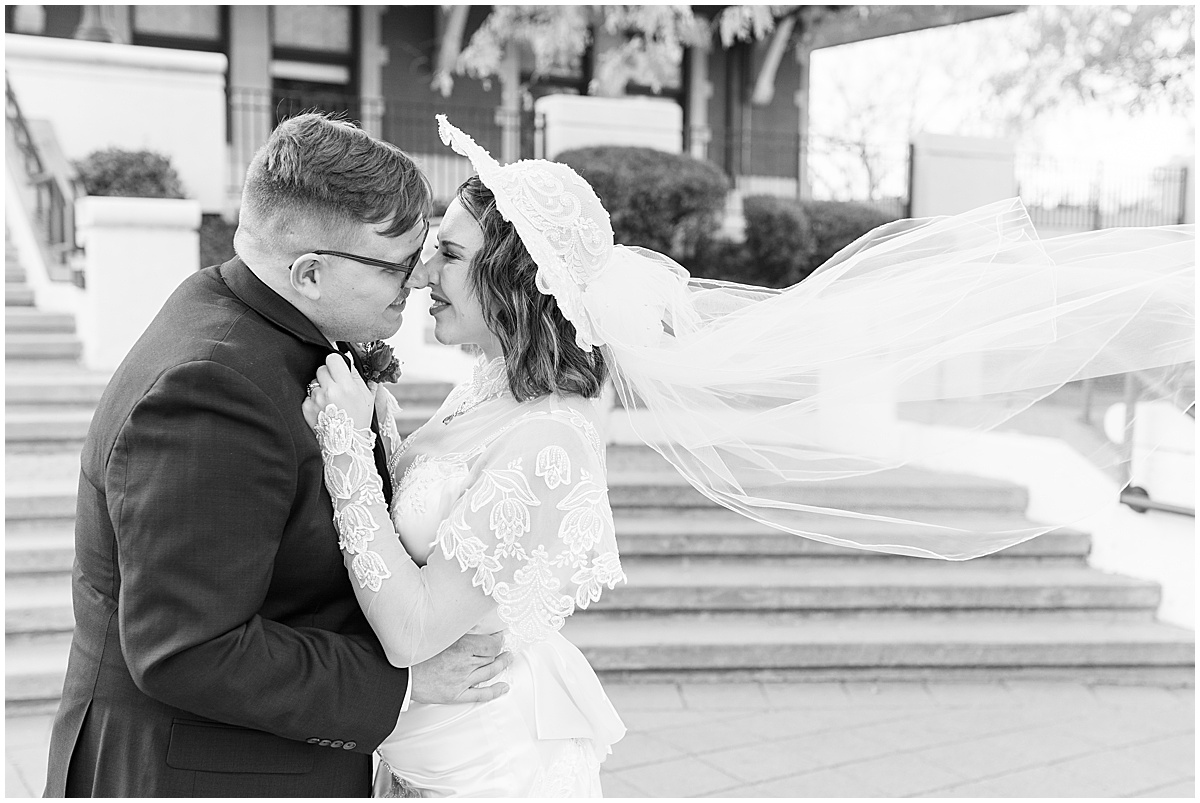 Brides veil blows in wind during wedding photos in Downtown Lafayette, Indiana
