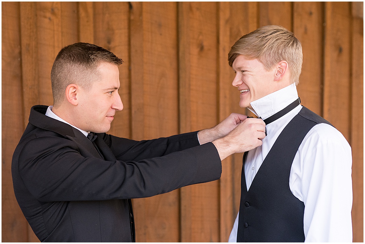 Groom having help with bowtie before fall wedding at 3 Fat Labs in Greencastle, Indiana