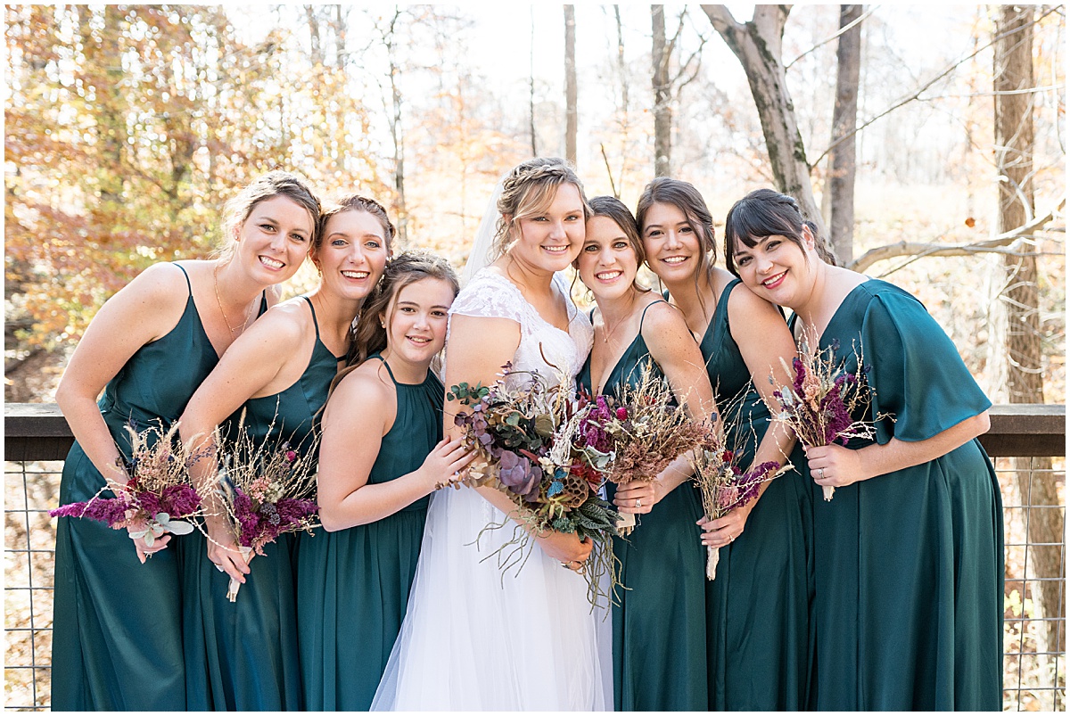 Bride huddles with bridesmaids before fall wedding at 3 Fat Labs in Greencastle, Indiana