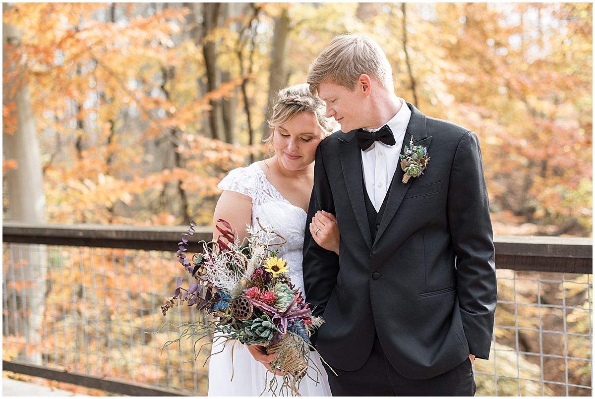 Couple admiring flowers at fall wedding at 3 Fat Labs in Greencastle, Indiana