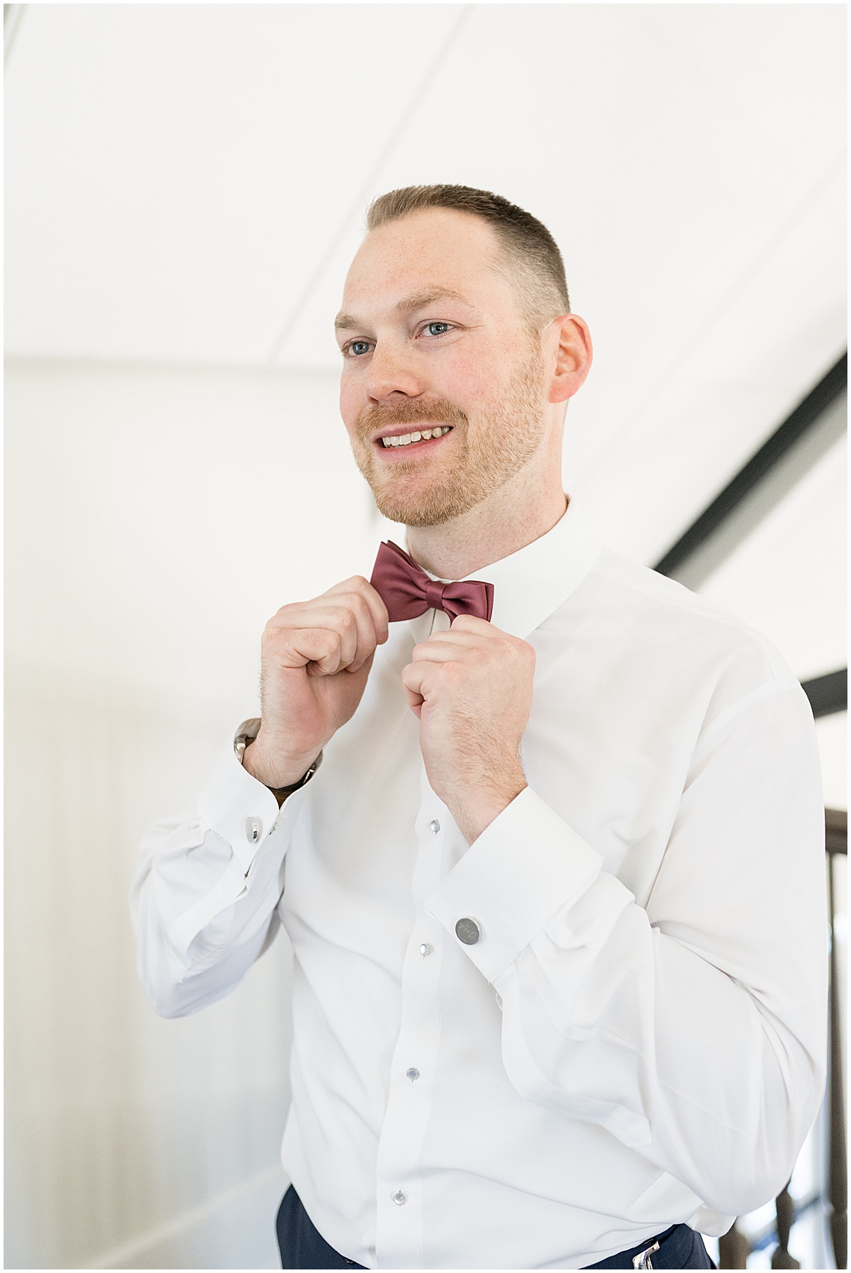 Groom adjusting tie at Iron & Ember events wedding in Carmel, Indiana