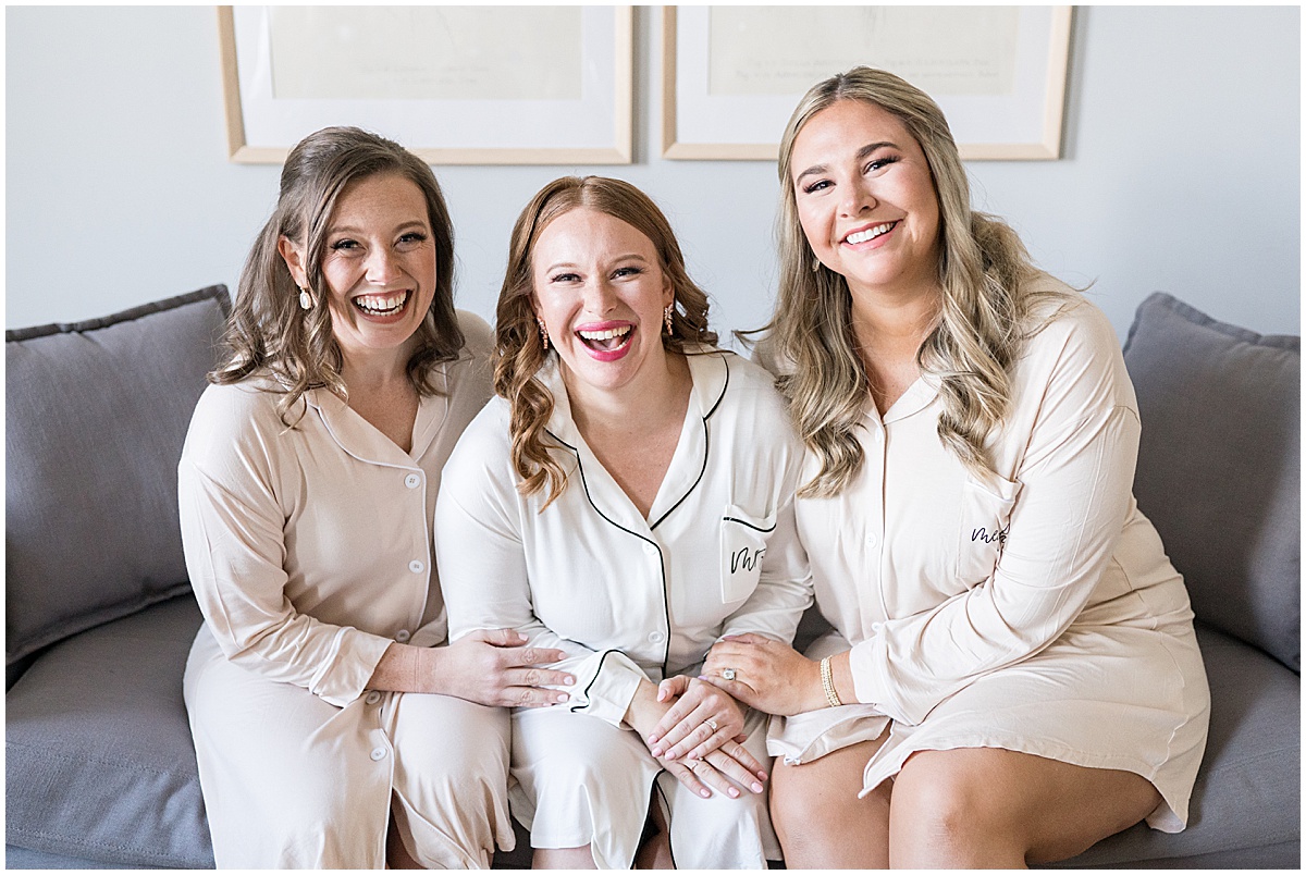 Bride with bridesmaids in robes before Iron & Ember events wedding in Carmel, Indiana