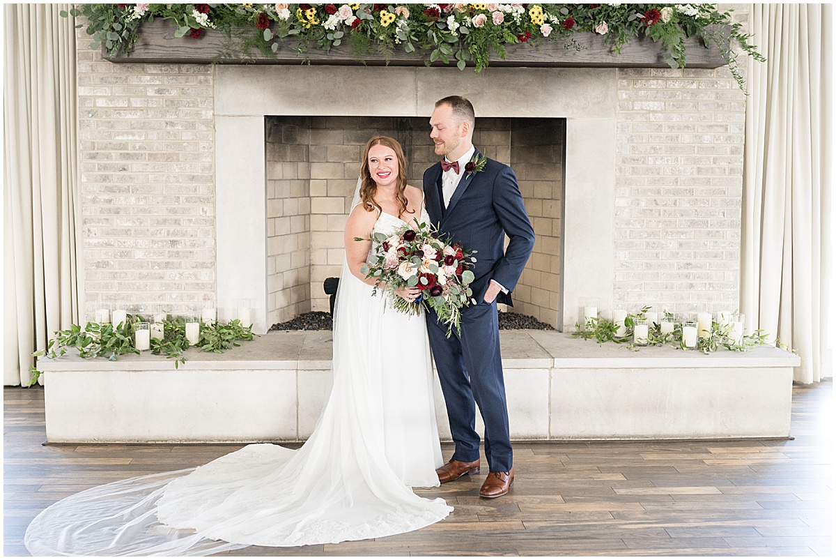 Bride and groom in front of fireplace at Iron & Ember events wedding in Carmel, Indiana