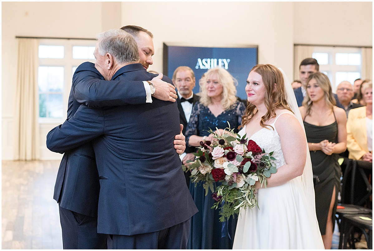 Groom hugs brides father at Iron & Ember events wedding in Carmel, Indiana