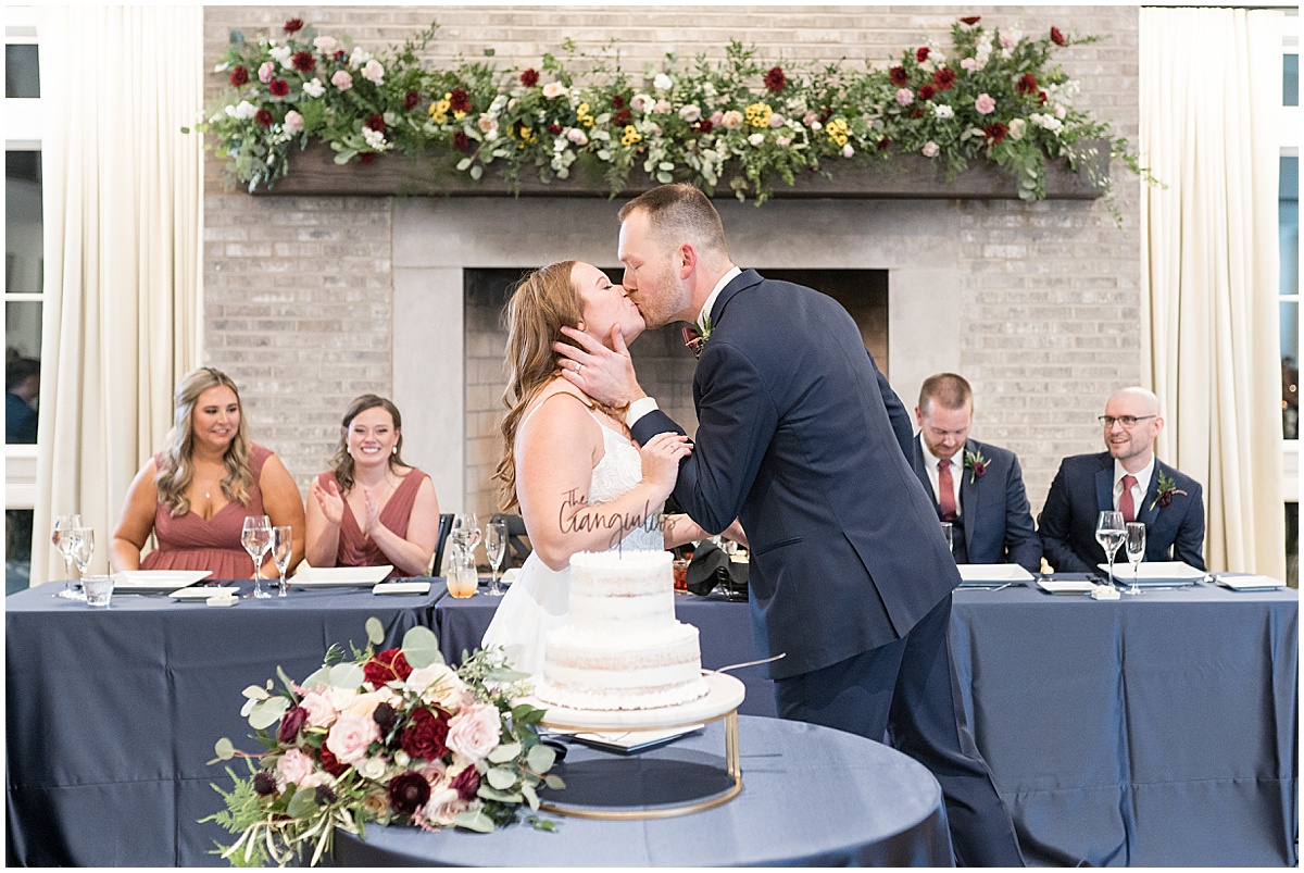 Bride and groom kiss after cake cutting at Iron & Ember events wedding in Carmel, Indiana