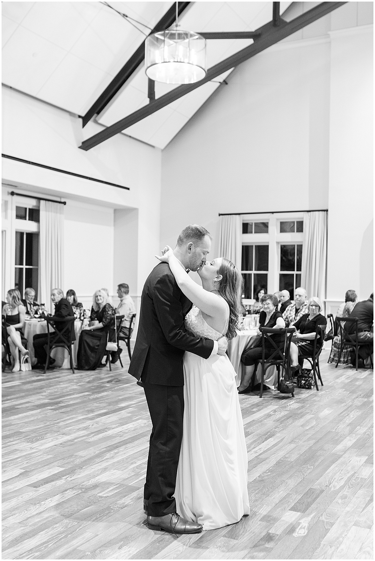 Couple kisses during first dance at Iron & Ember events wedding in Carmel, Indiana