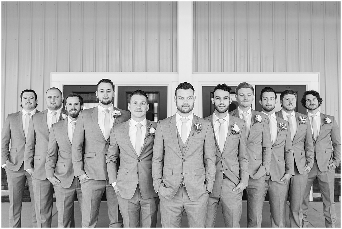 Groomsmen with serious faces outside wedding at New Journey Farms