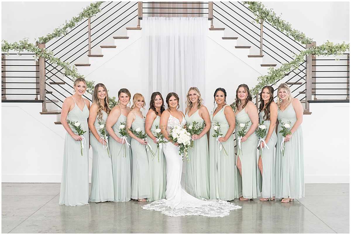 Bride and bridesmaids in front of grand staircase at wedding at New Journey Farms