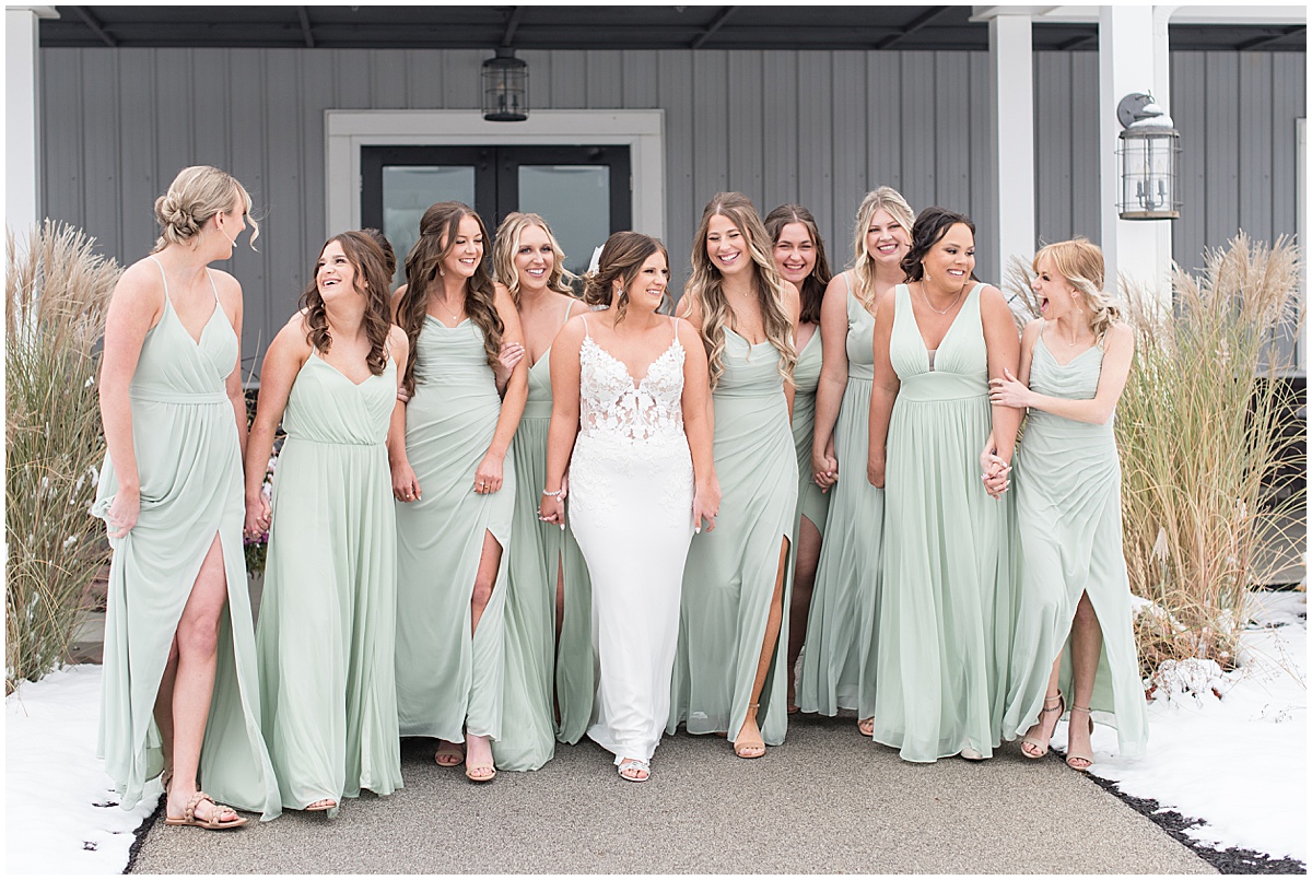 Bride and bridesmaids hold hands walking outside wedding at New Journey Farms