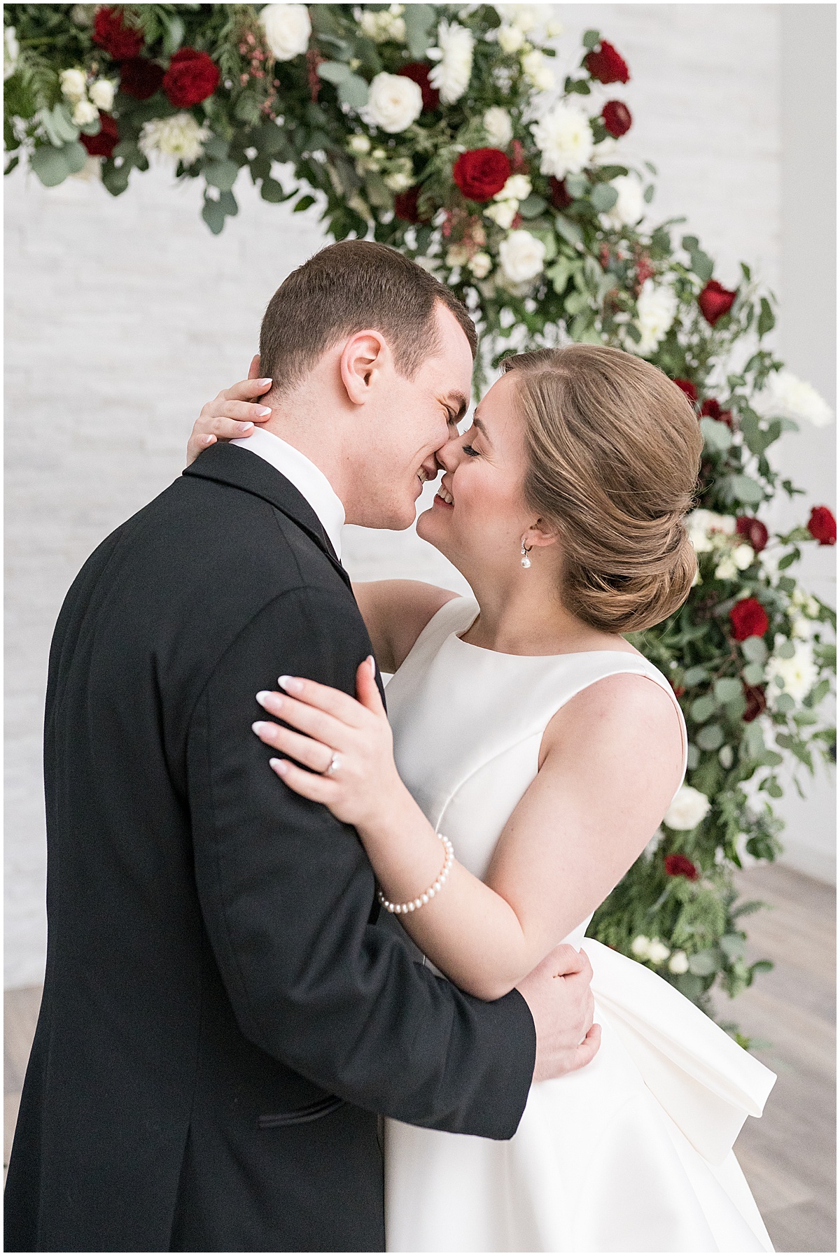 Bride and groom kiss under flowers before Allure on the Lake wedding in Chesterton, Indiana