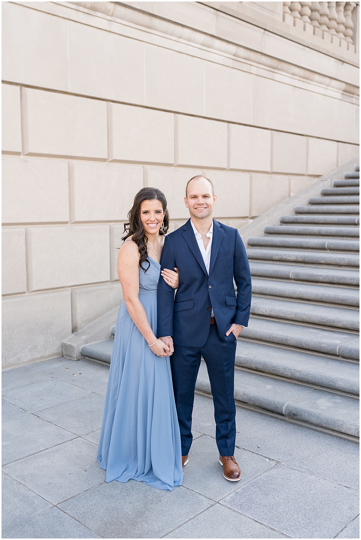 Couple hold hands in front of steps at Indiana War Memorial during Downtown Engagement Photos