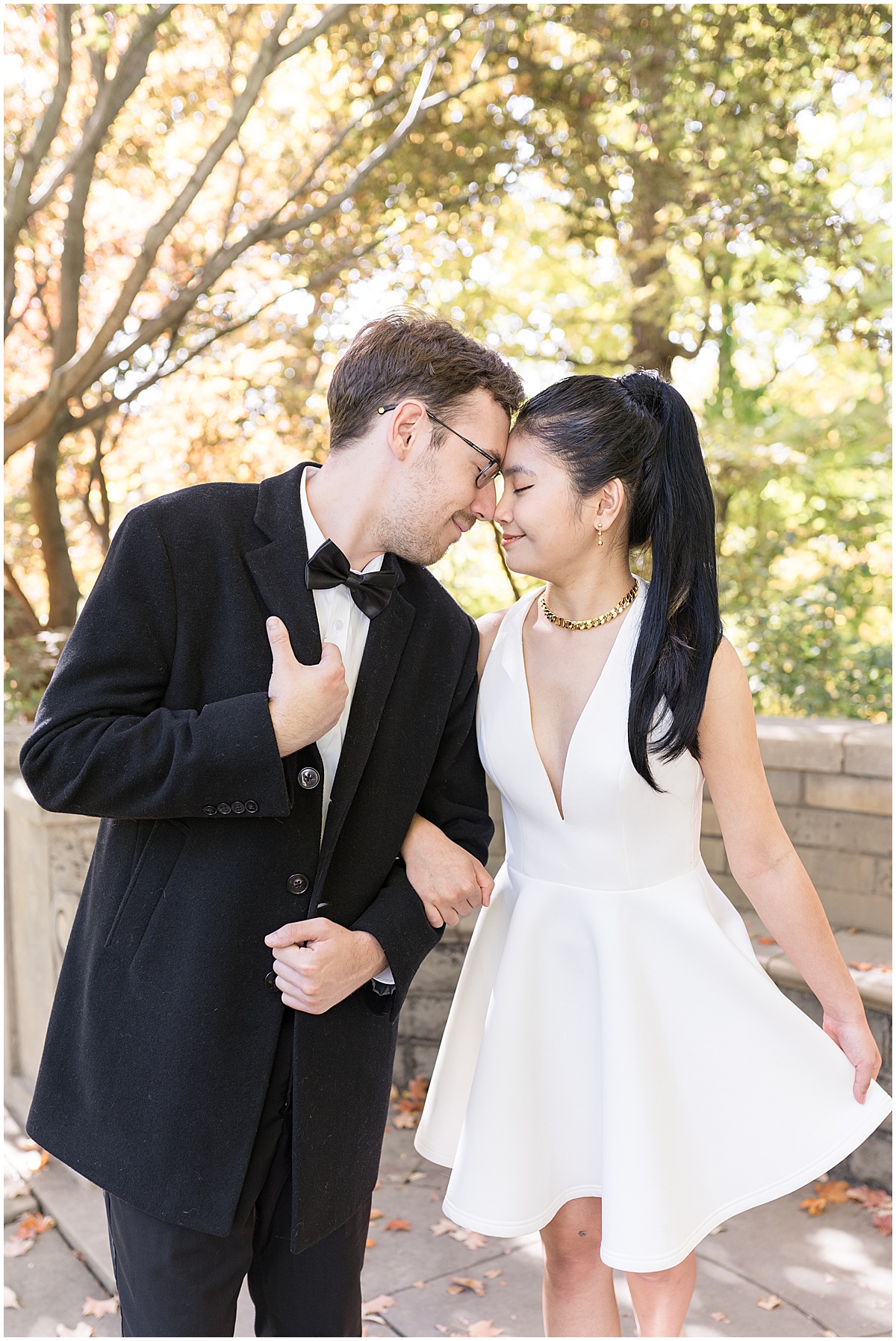 Bride to be showcases white satin dress during garden engagement photos at Newfields in Indianapolis