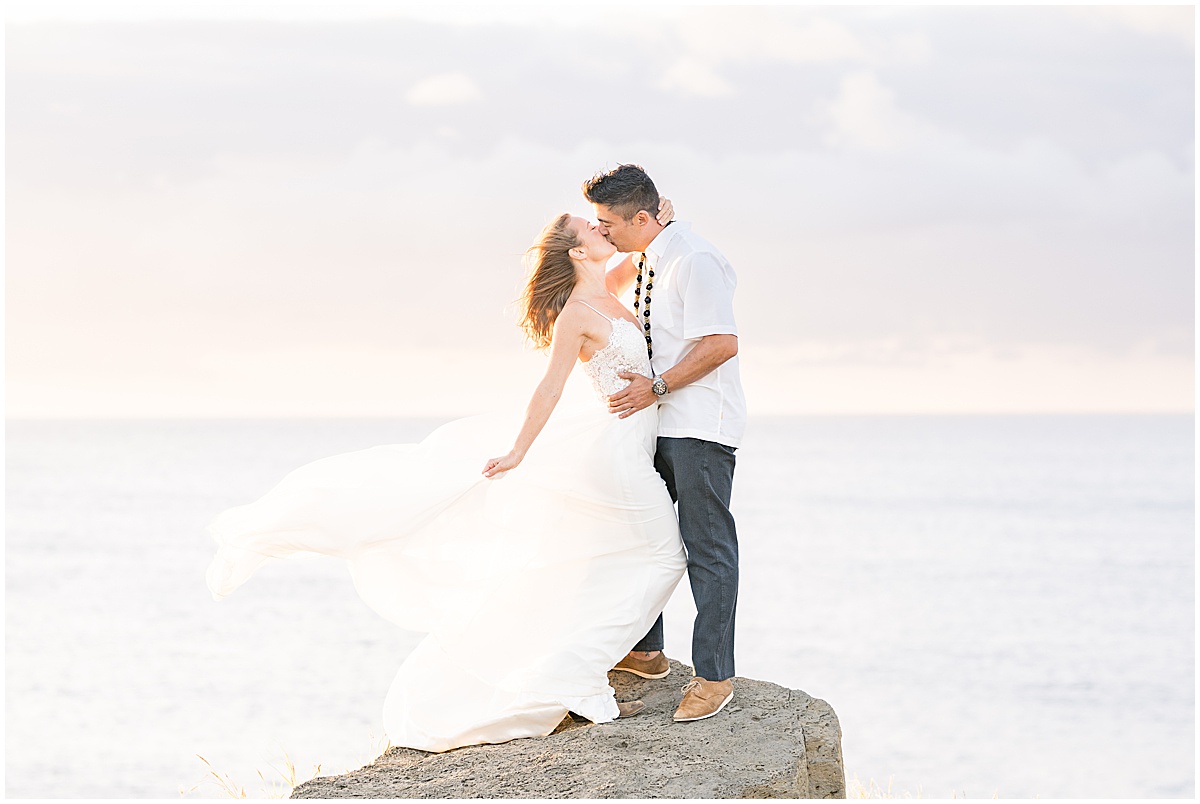 Couple kissing on rock at South Point Hawaii elopement photographed by Victoria Rayburn Photography