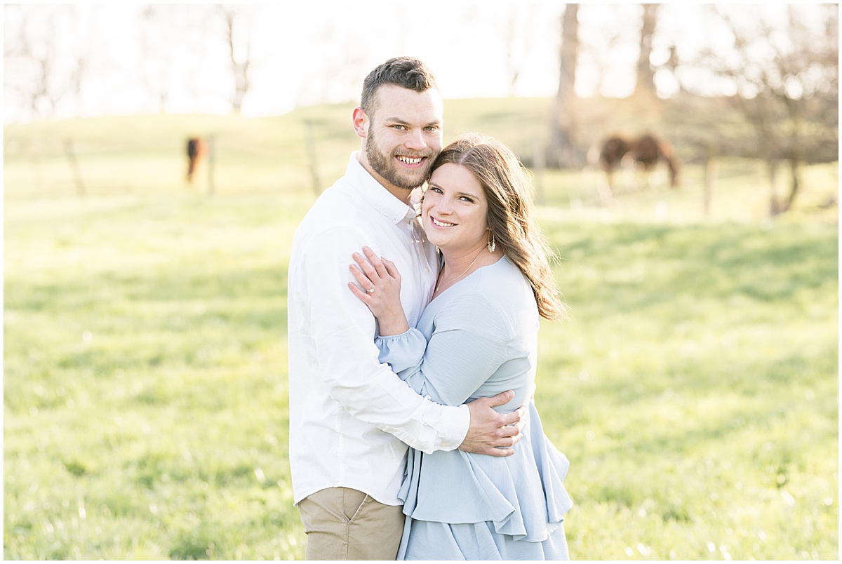 Couple hug in front of horse pasture featured in the “Victoria Rayburn Photography Best of Engagement Photos 2022” blog post.