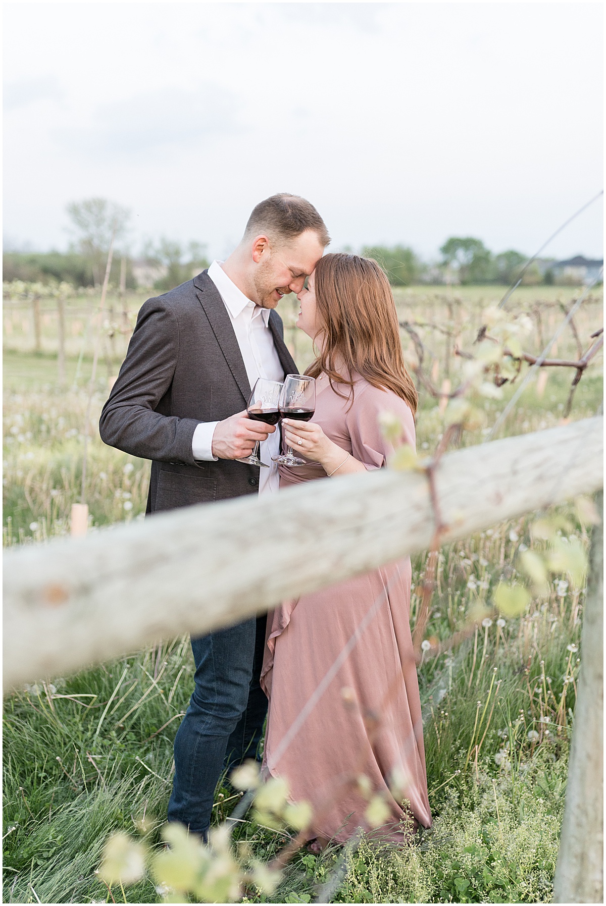 Couple cheers in vineyard featured in the “Victoria Rayburn Photography Best of Engagement Photos 2022” blog post.