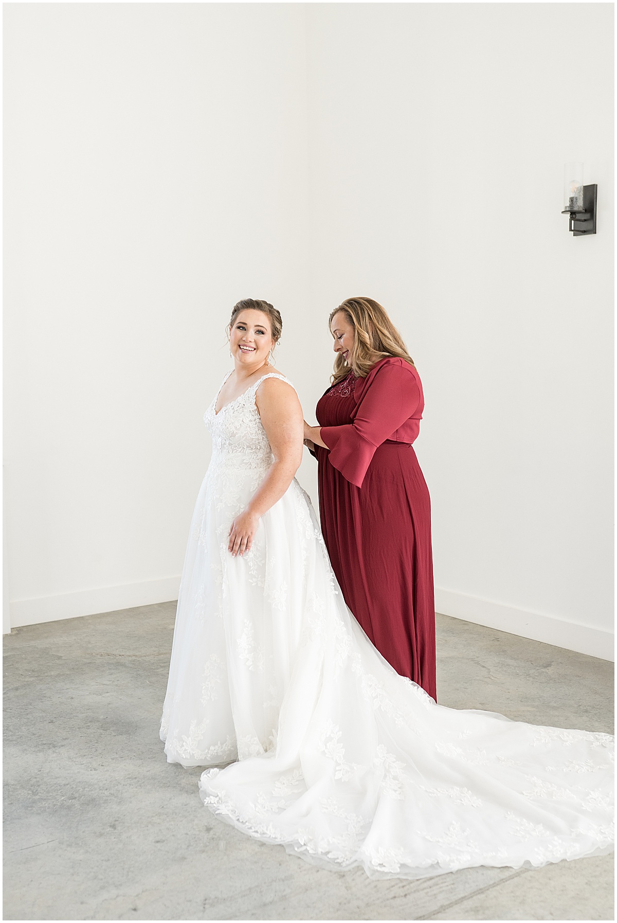 Bride getting help putting on dress for December wedding at New Journey Farms in Lafayette, Indiana photographed by Victoria Rayburn Photography