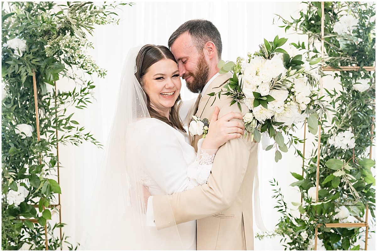 Bride and groom hug next to floral arch at Delphi Opera House wedding photographed by Victoria Rayburn Photography