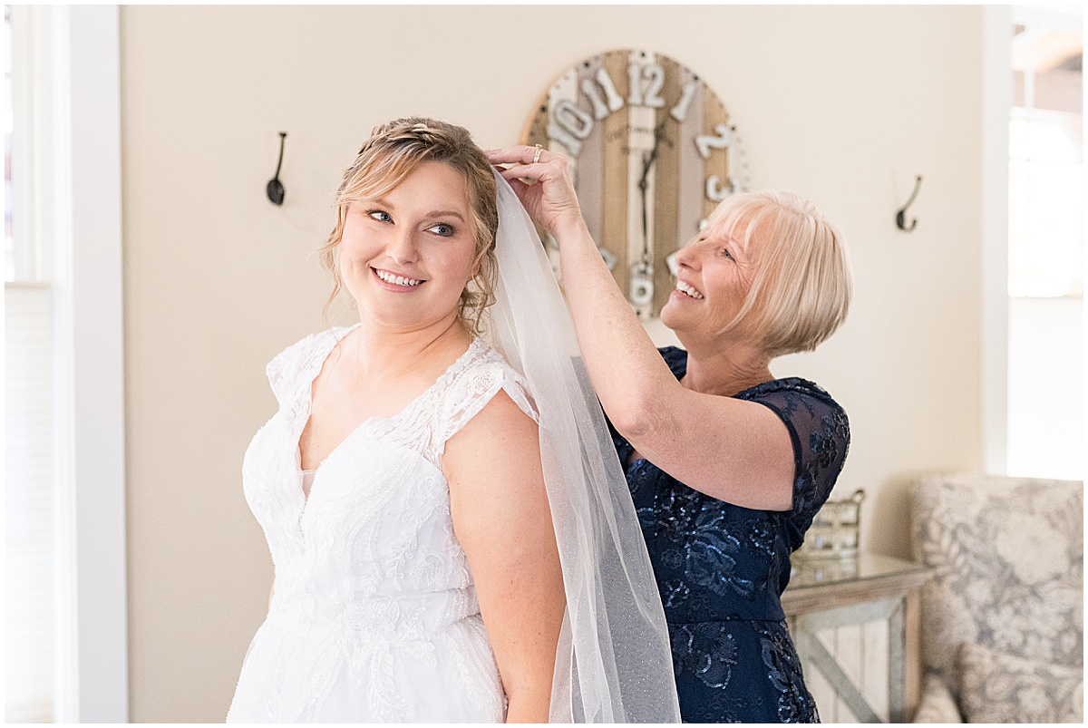 Bride has help putting on her veil for fall wedding at 3 Fat Labs in Greencastle, Indiana photographed by Victoria Rayburn Photography