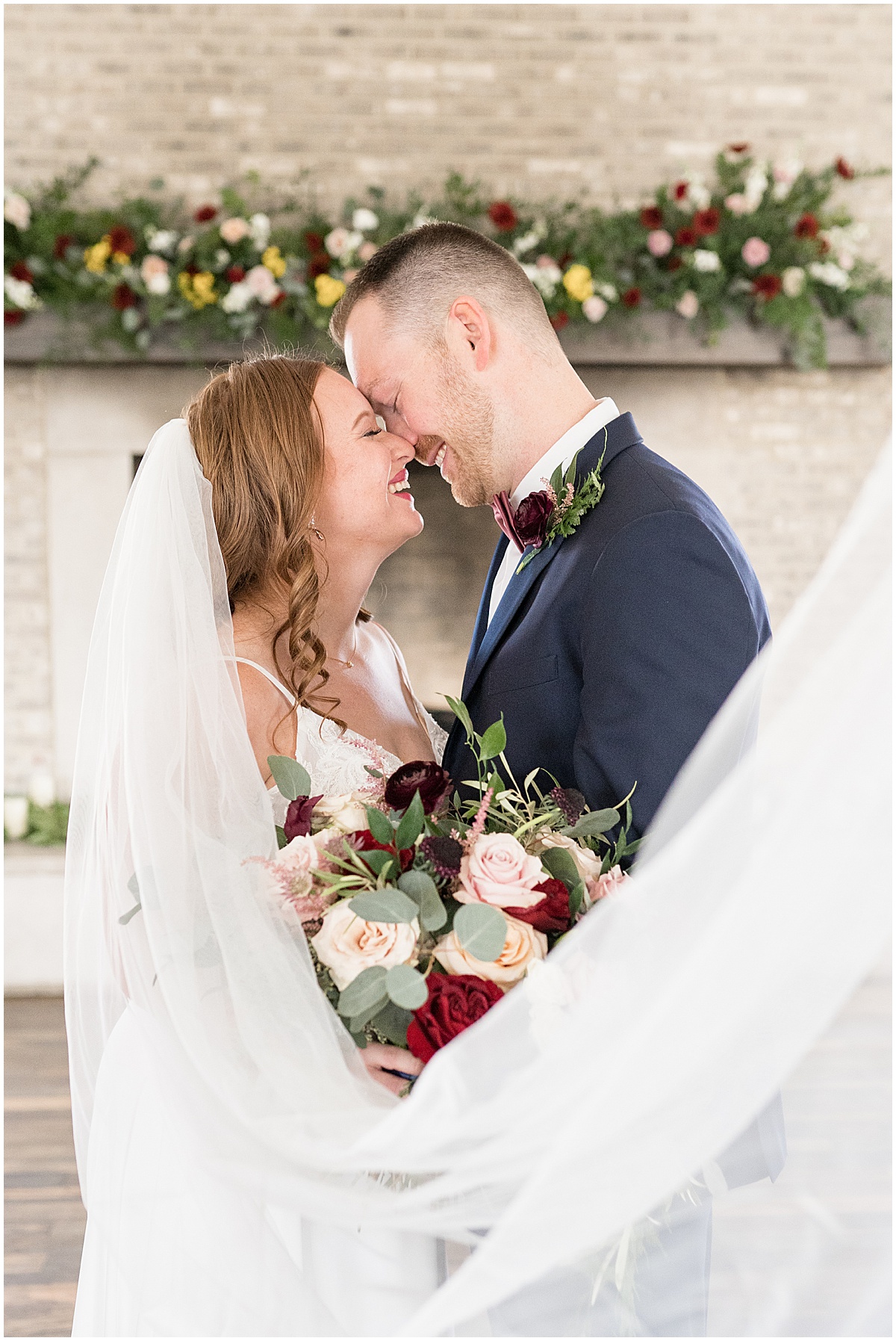 Bride kiss in front of fireplace at Iron & Ember Events wedding in Carmel, Indiana by Victoria Rayburn Photography