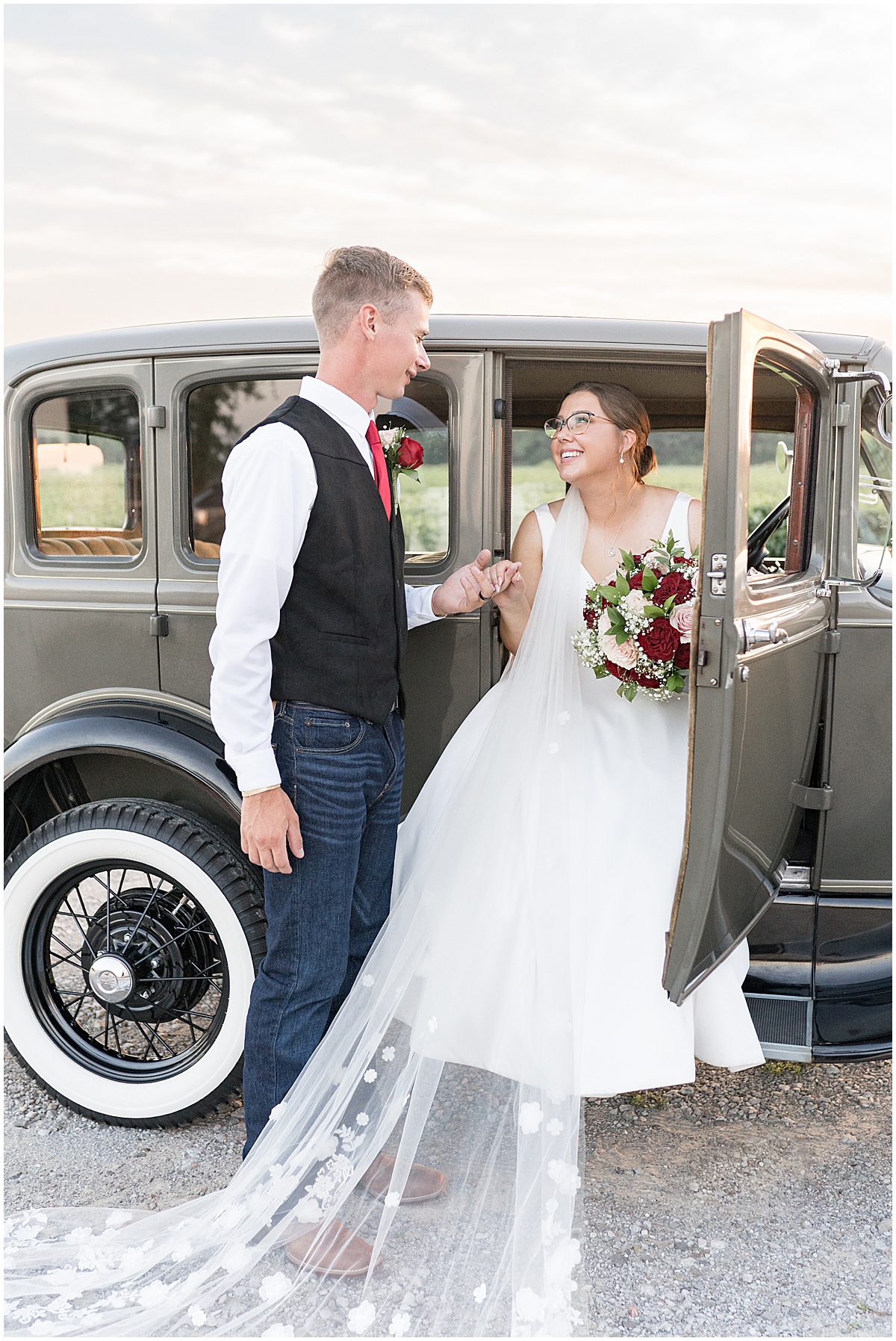 Groom helps bride get out of vintage car at Churchill Farms wedding in Lake Village, Indiana photographed by Victoria Rayburn Photography