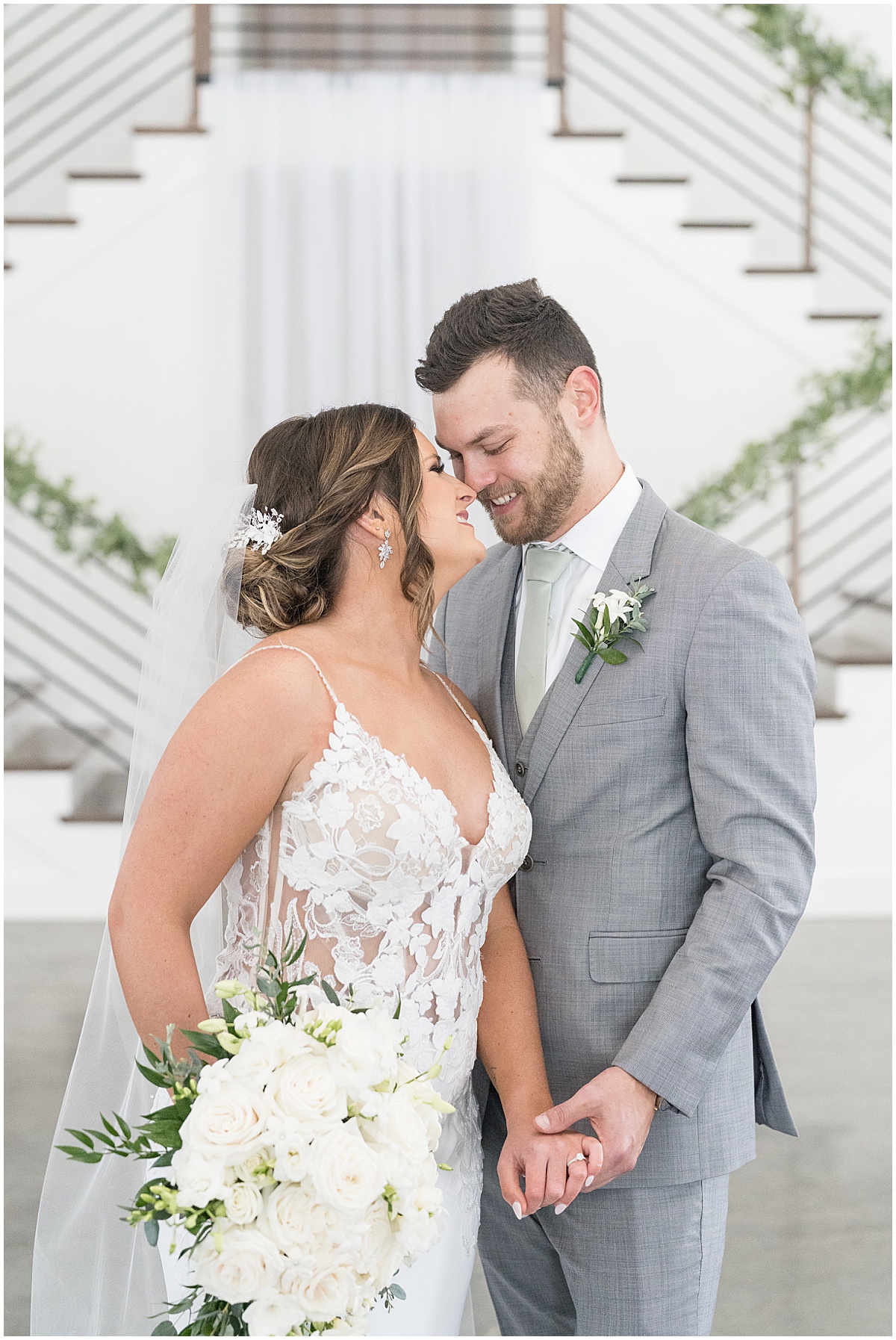 Bride and groom kiss in front of staircase at wedding at New Journey Farms in Lafayette, Indiana photographed by Victoria Rayburn Photography