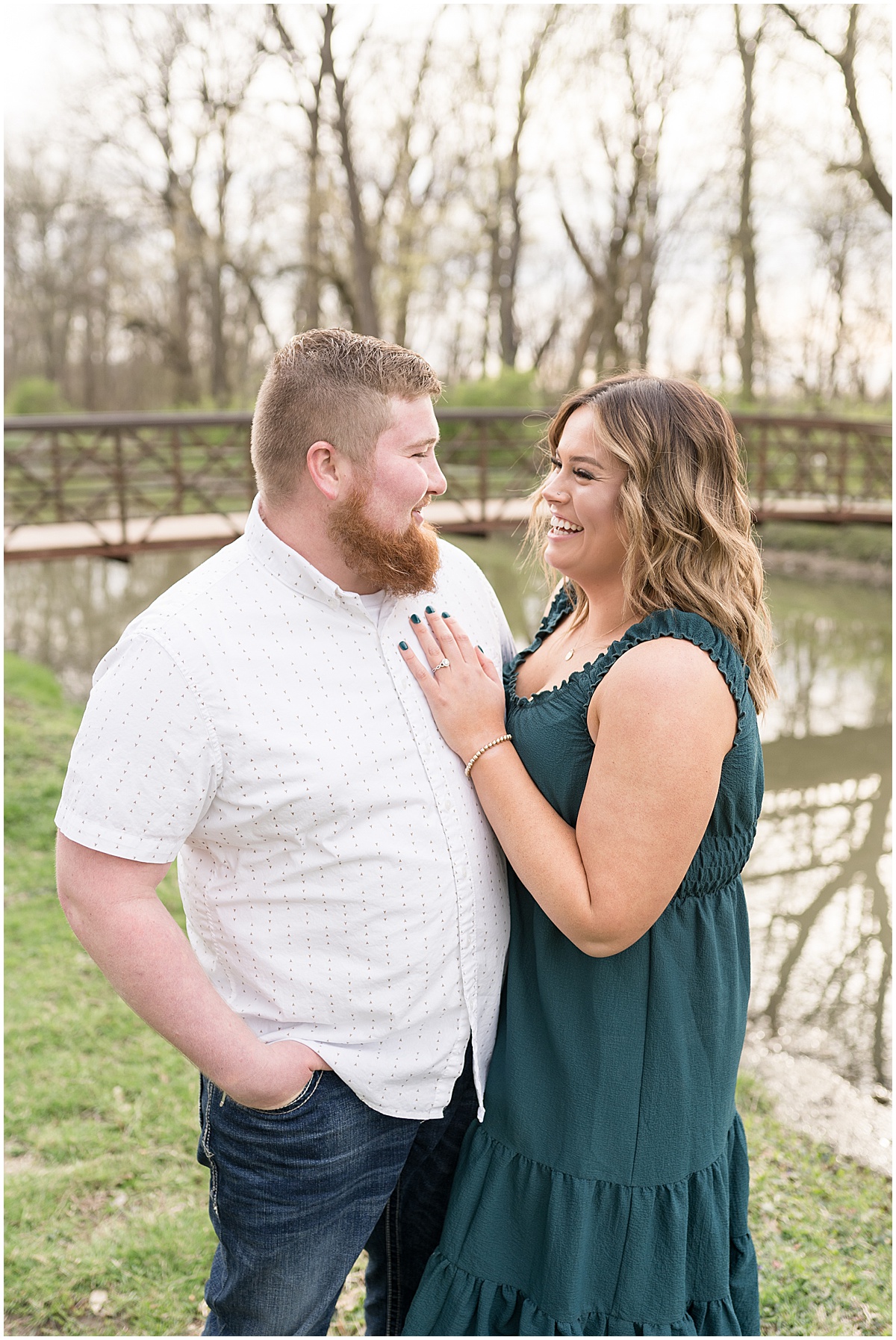 Couple laughs by water at Holcomb Gardens spring engagement photos
