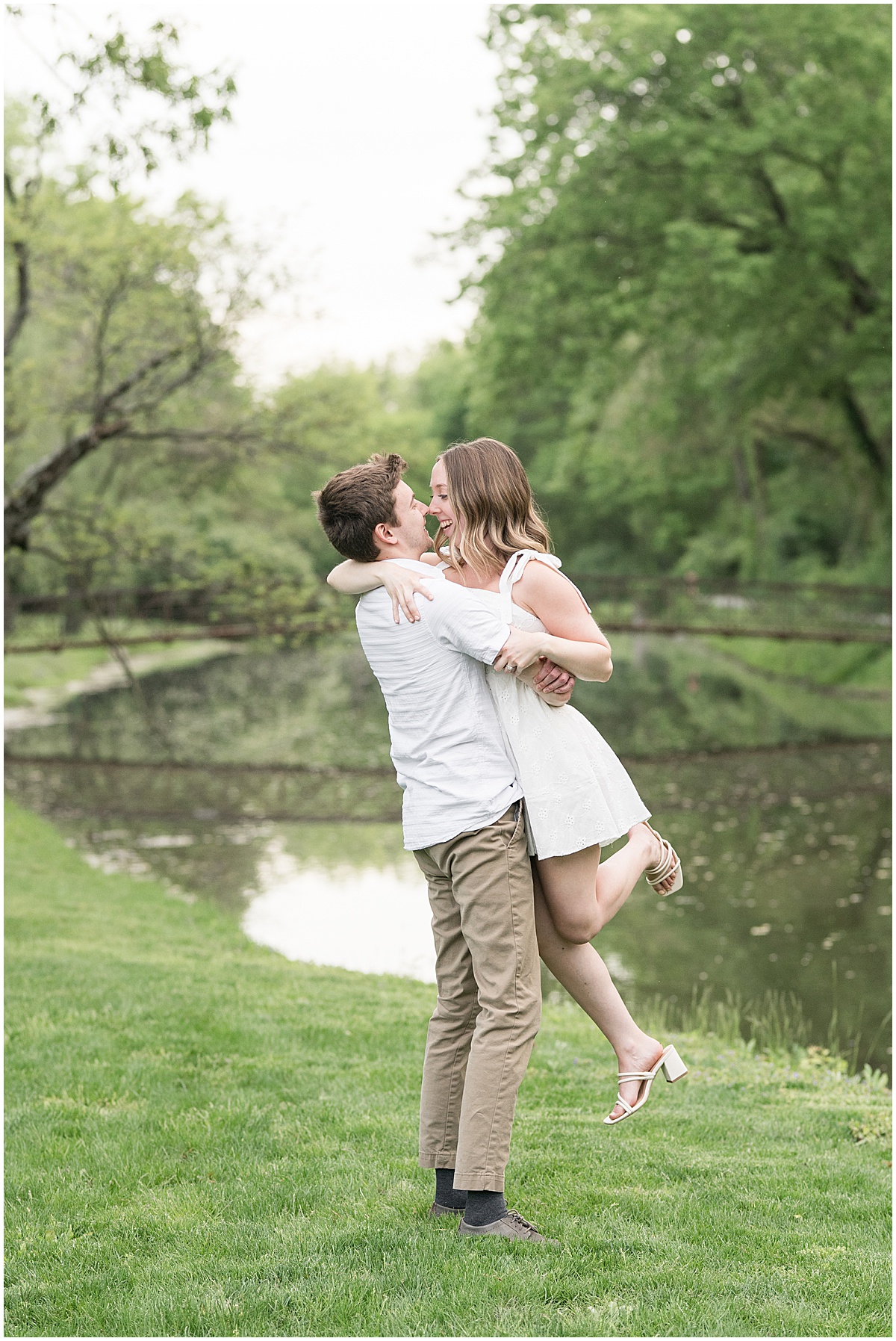Man lifts fiancee during engagement photos at Holcomb Gardens in Indianapolis.